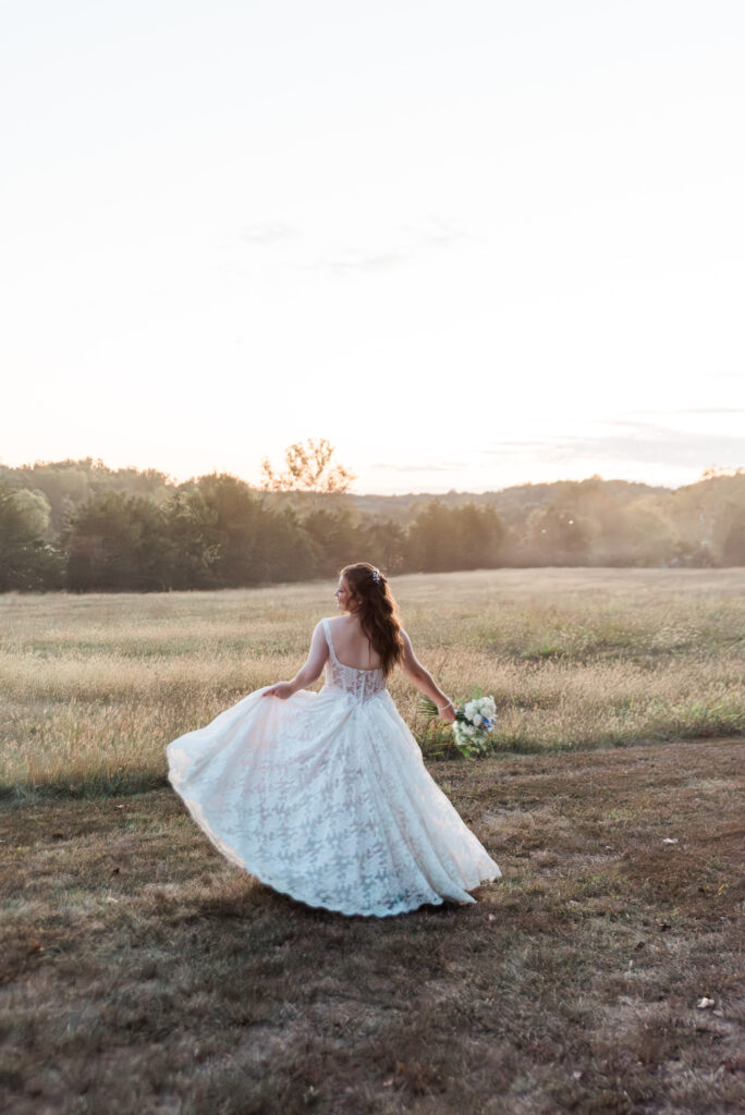 Alison + Sterlen elegant rustic bride holding flowers and twirling outdoors with landscape at wedding venues st louis