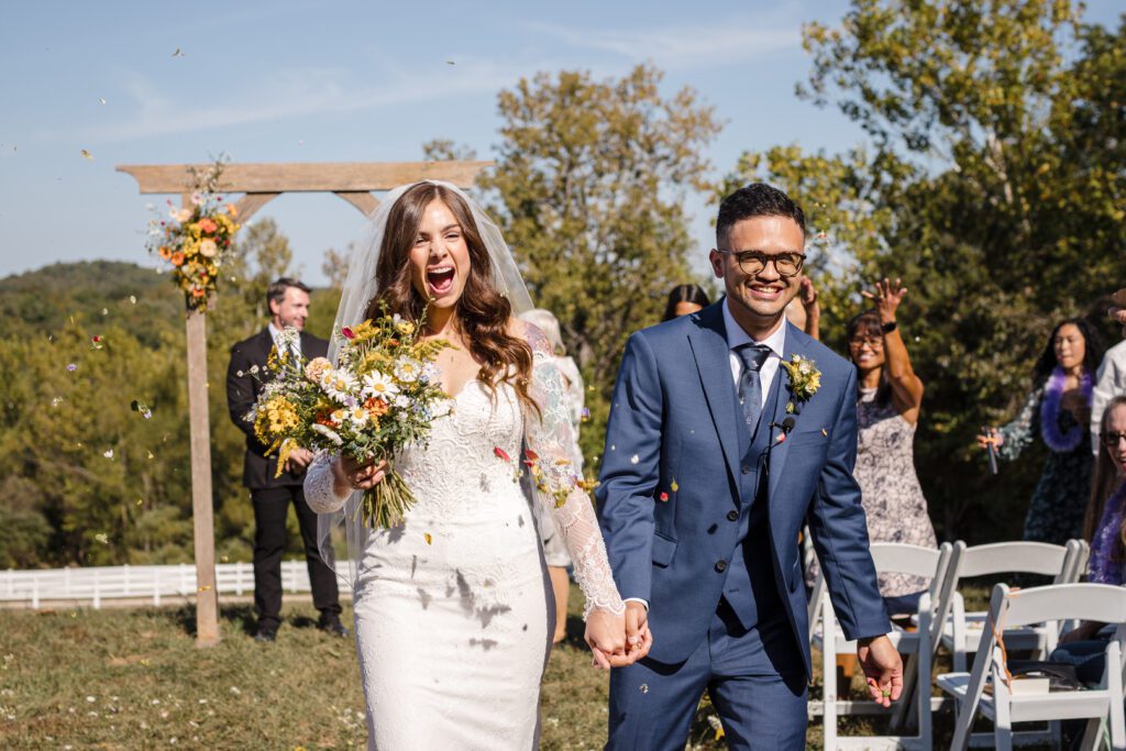 Gregorio + Macy couple walking through applause at wedding venues st louis