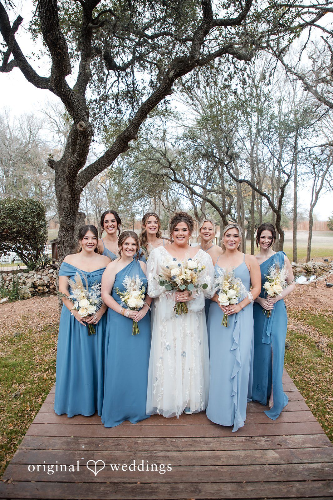 Kelsey + Riley The bride stands with her bridesmaids, all holding bouquets.
