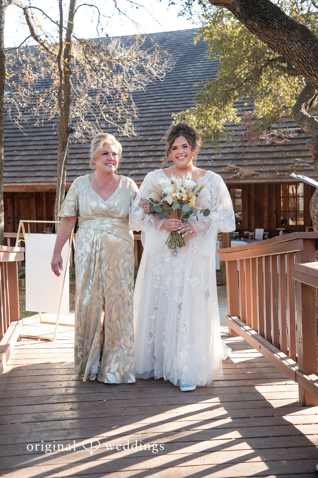 Kelsey + Riley The bride walks with companions, holding her bouquet happily.