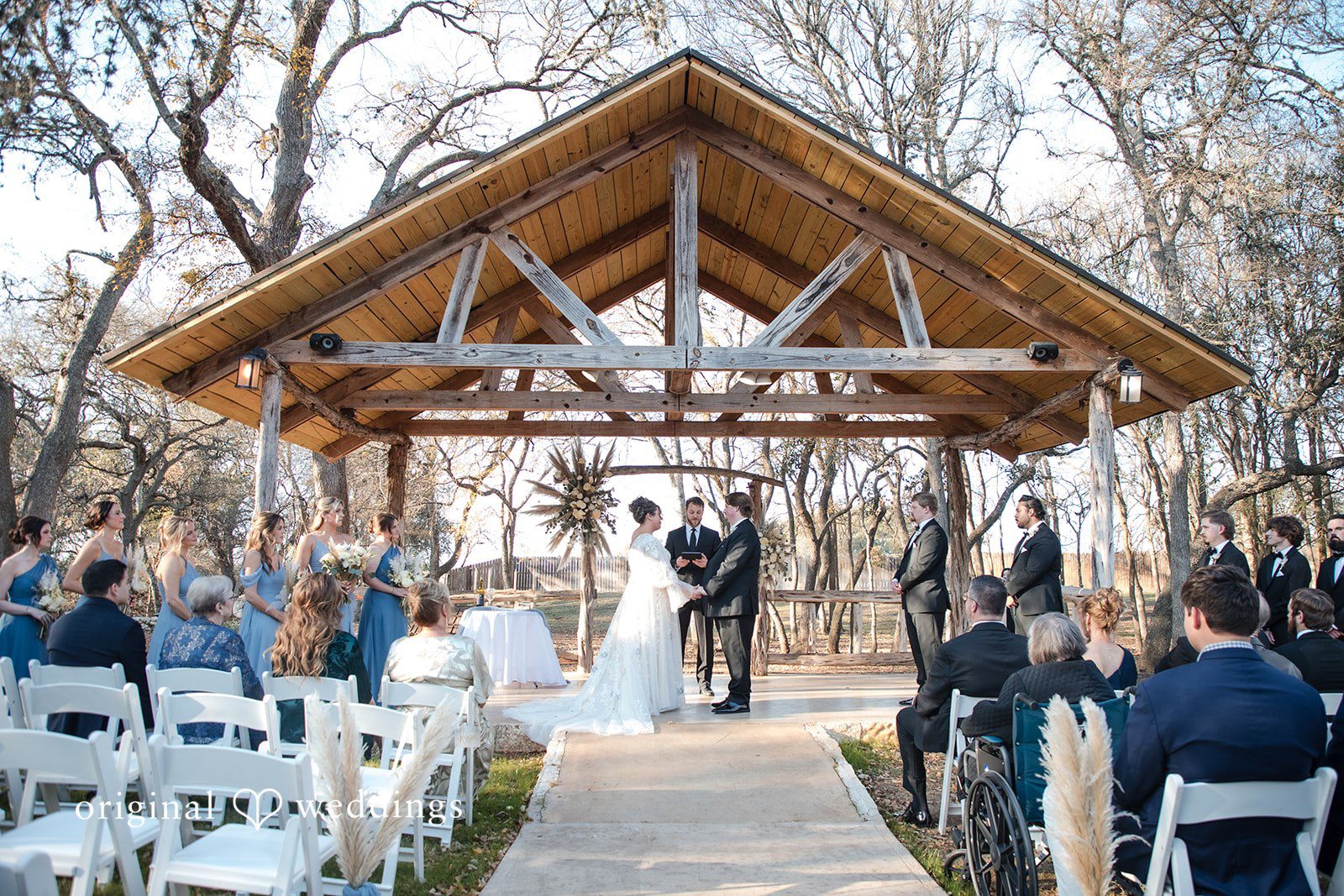 Kelsey + Riley A wide view shows the ceremony setup with guests seated outdoors.