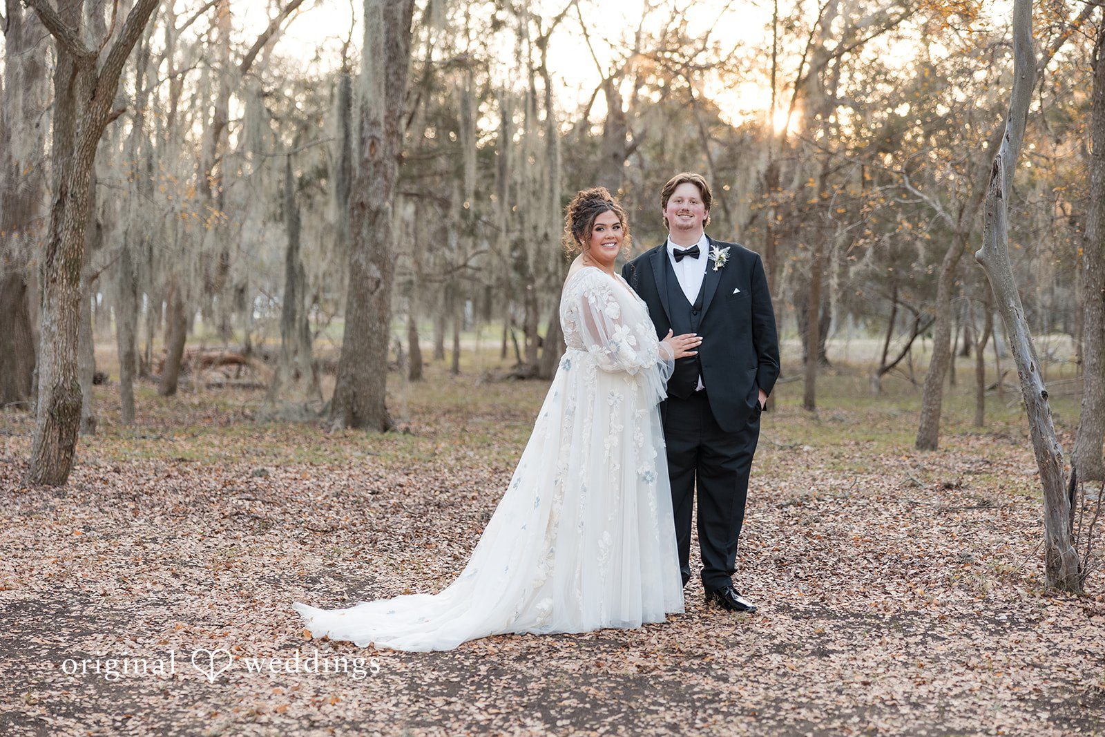Kelsey + Riley The bride and groom pose together in a natural wooded setting.