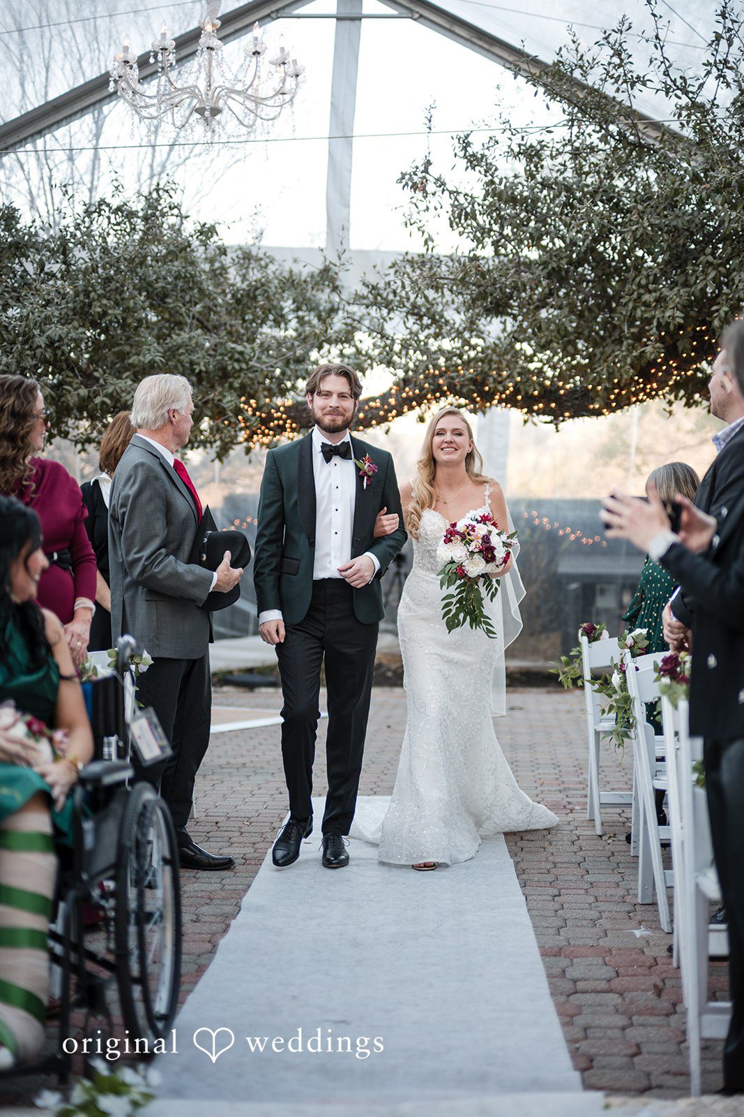 The bride and groom walk down the aisle hand in hand