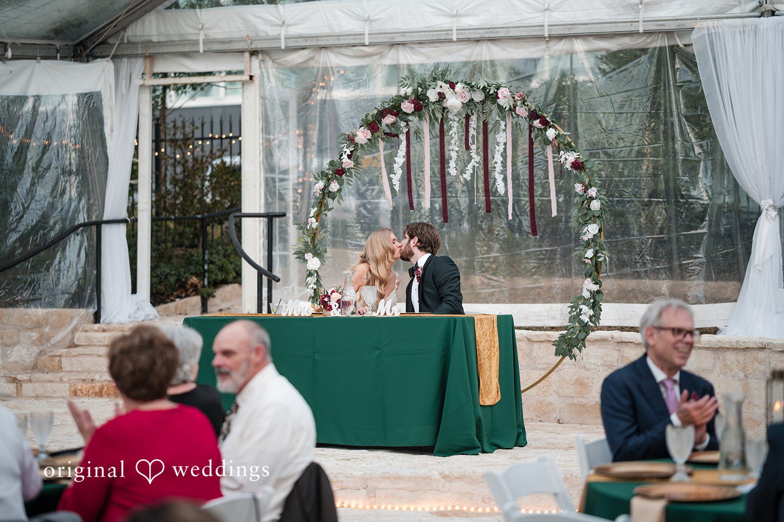 The couple shares a kiss at their wedding reception