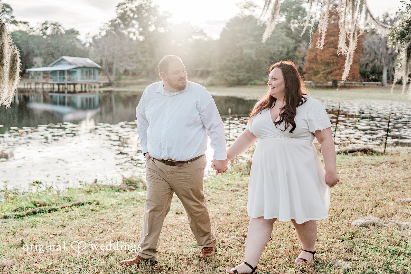 Couple holding hands while walking by the lake side