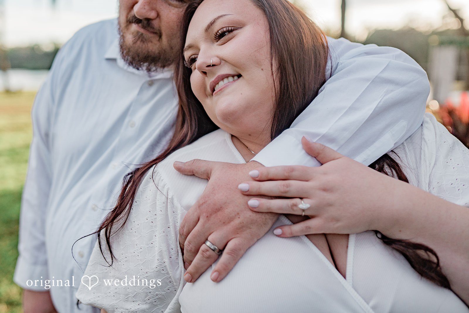 The couple holding hands and showing the engagement ring at The Barn at Crescent Lake in Odessa