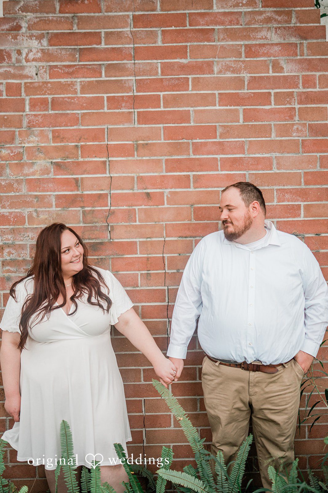 Romantic hand-in-hand engagement pose