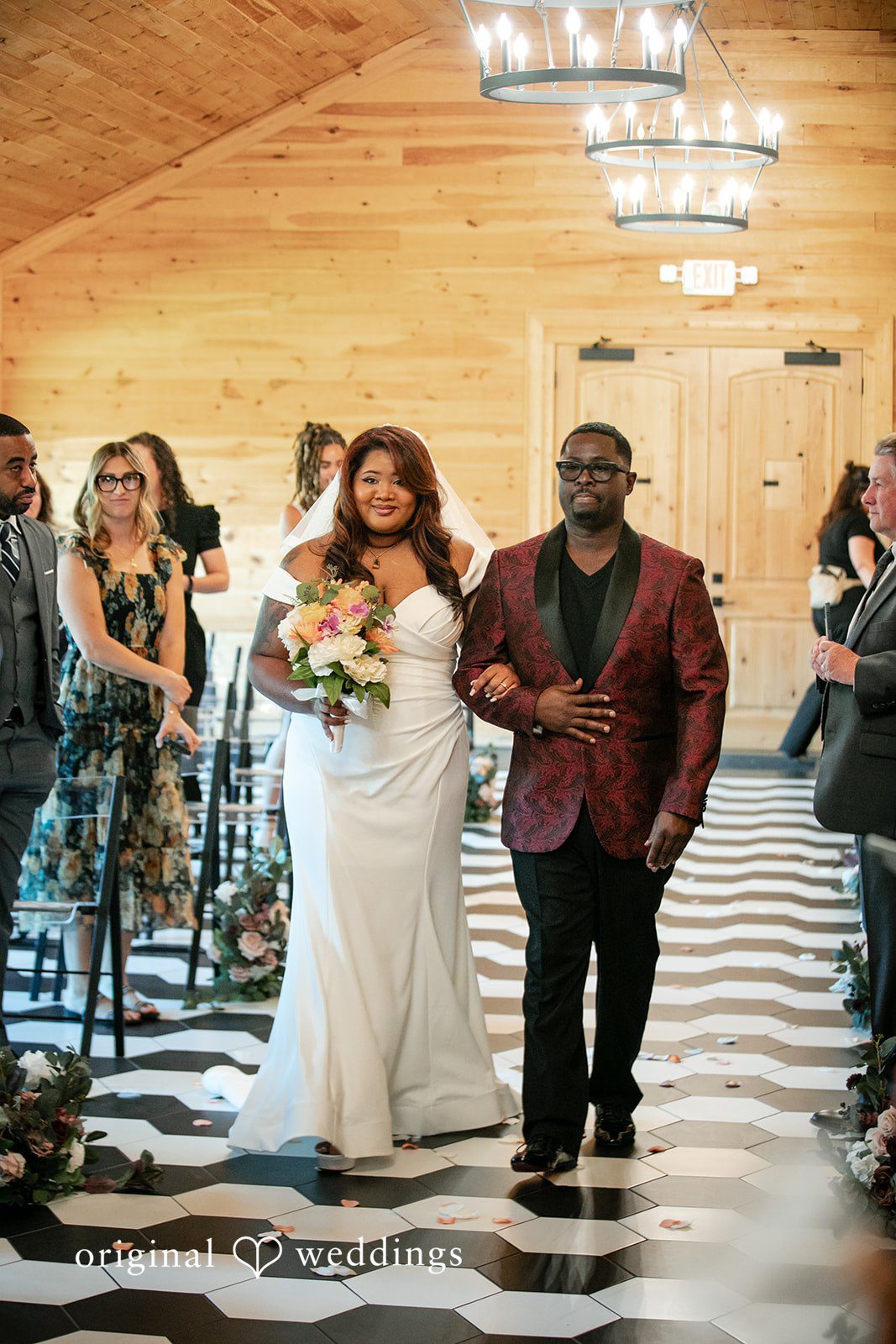 The bride walks down the aisle at The Black Barn