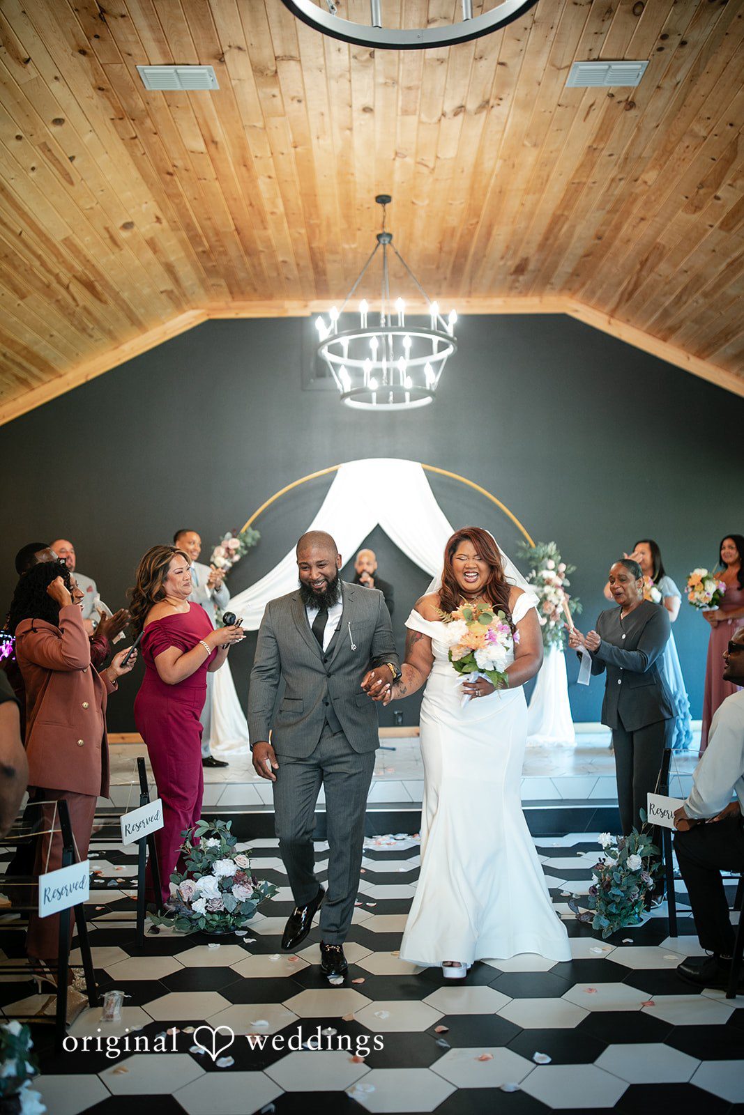 The couple joyfully exits the hall after their wedding ceremony