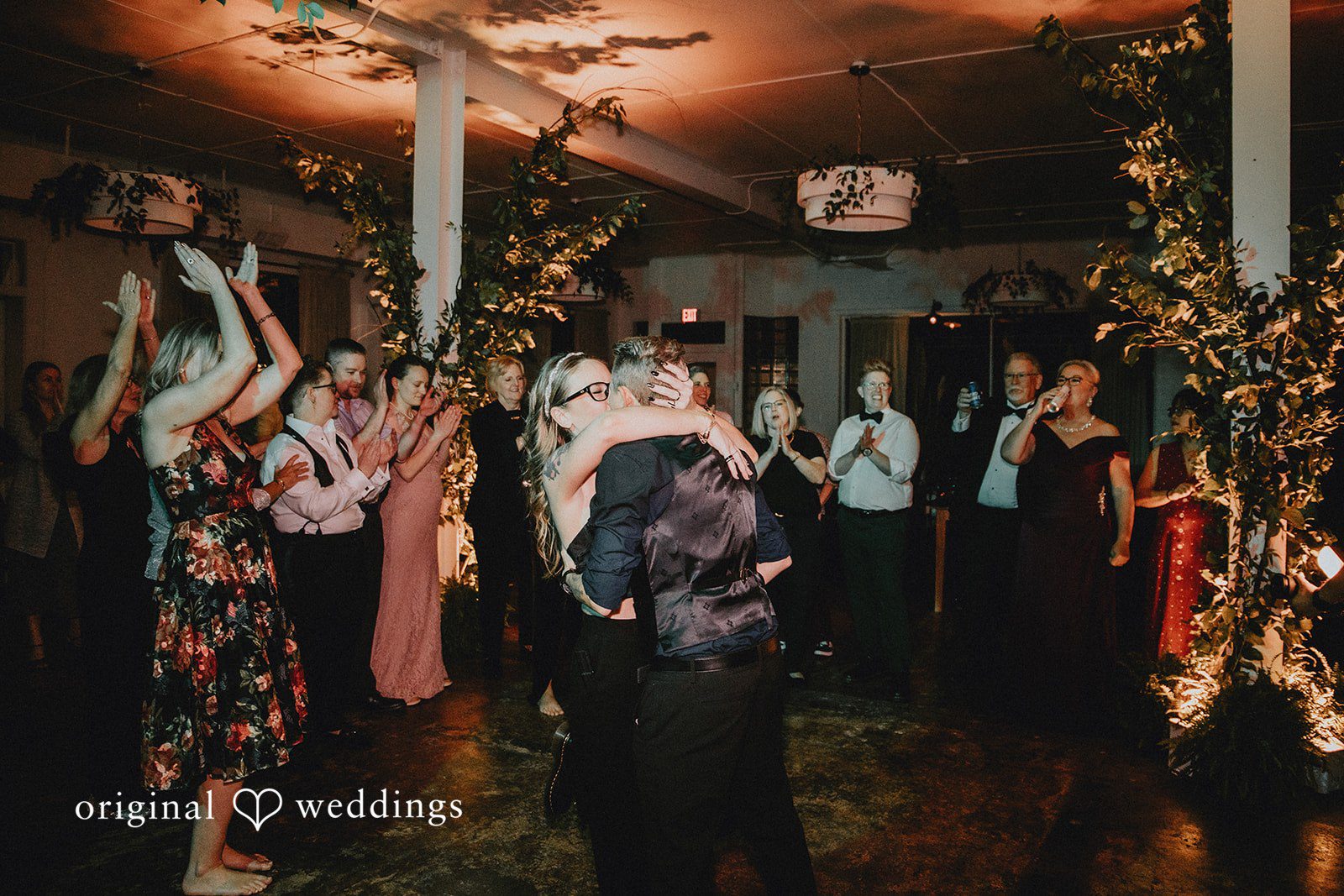 Dianna + Devin The wedding party cheers the couple on as they share a romantic kiss