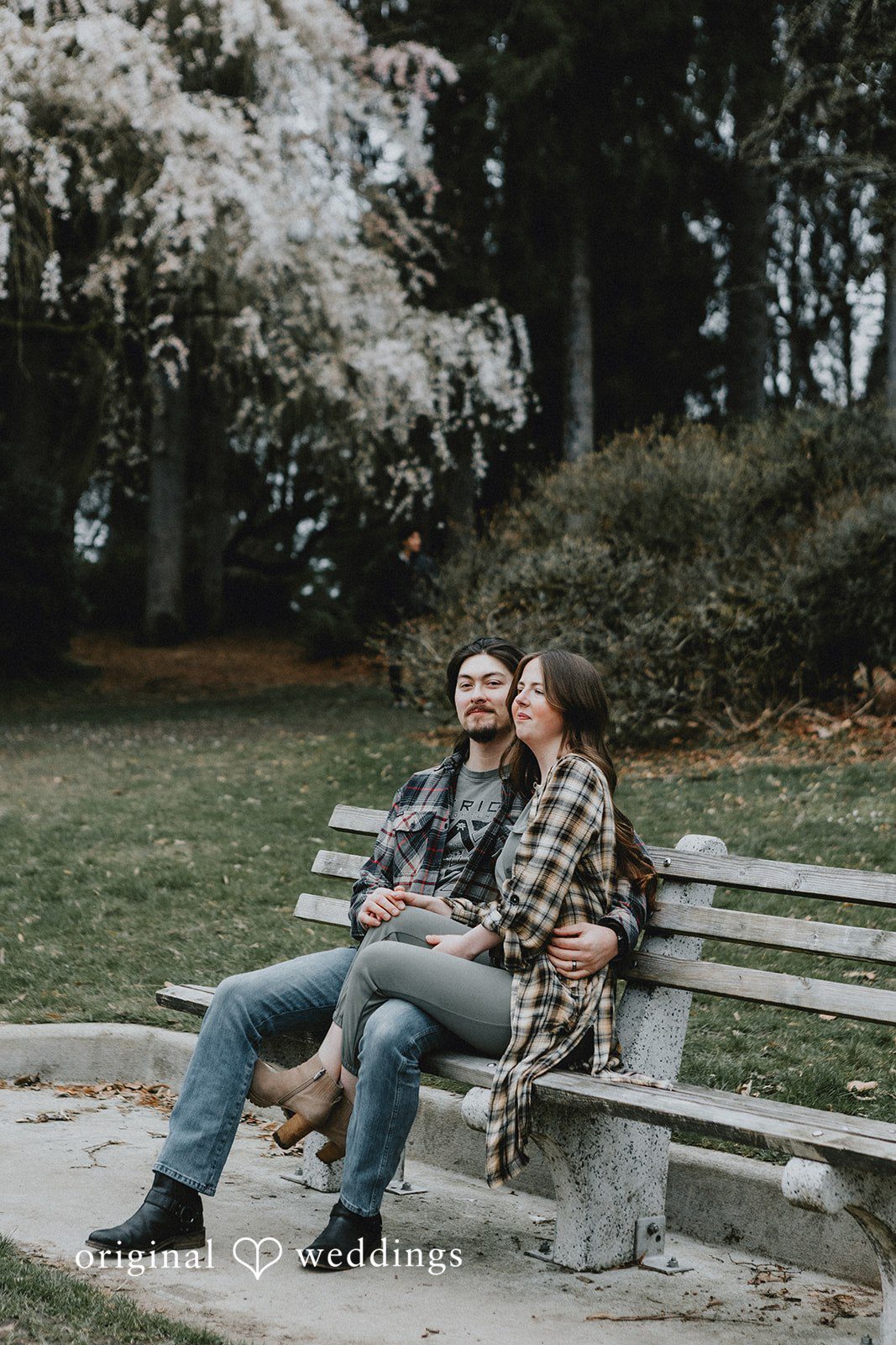 Engagement photography services by Original Weddings capturing couple sitting on bench at Volunteer Park