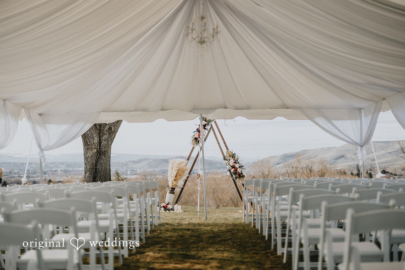 Parsa + Kiley Elegant white chairs are arranged for a romantic outdoor wedding ceremony, beautifully captured through Seattle wedding photography.