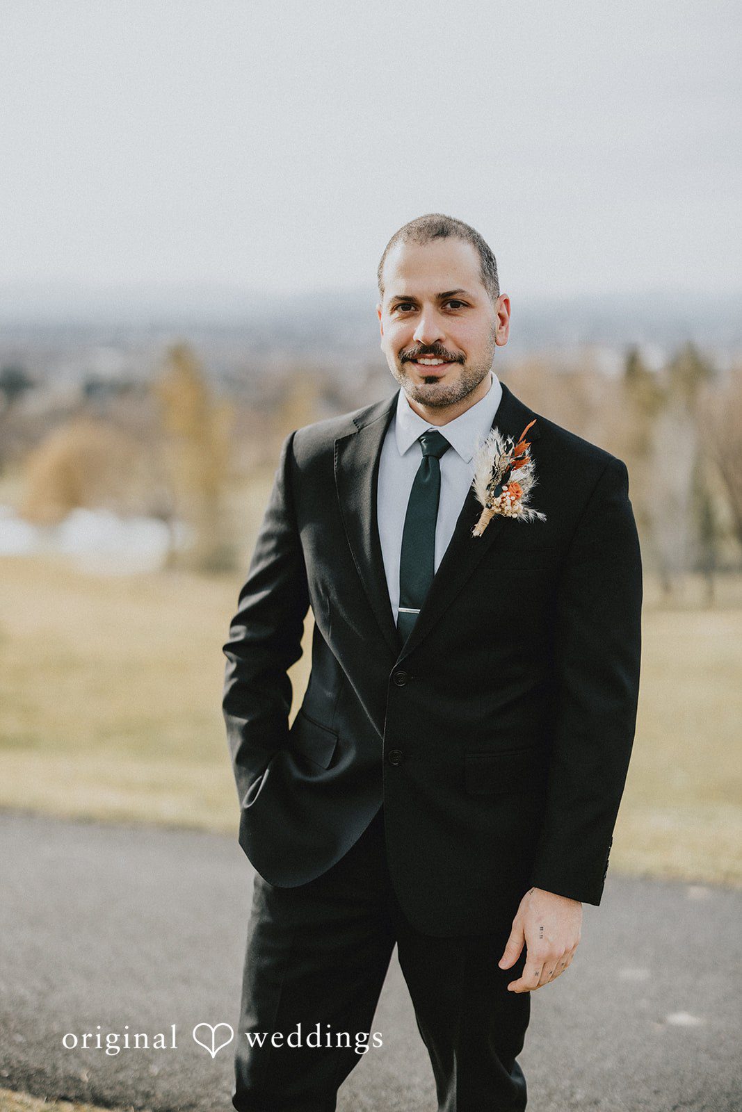 Parsa + Kiley The groom poses outdoors with a calm and confident expression.