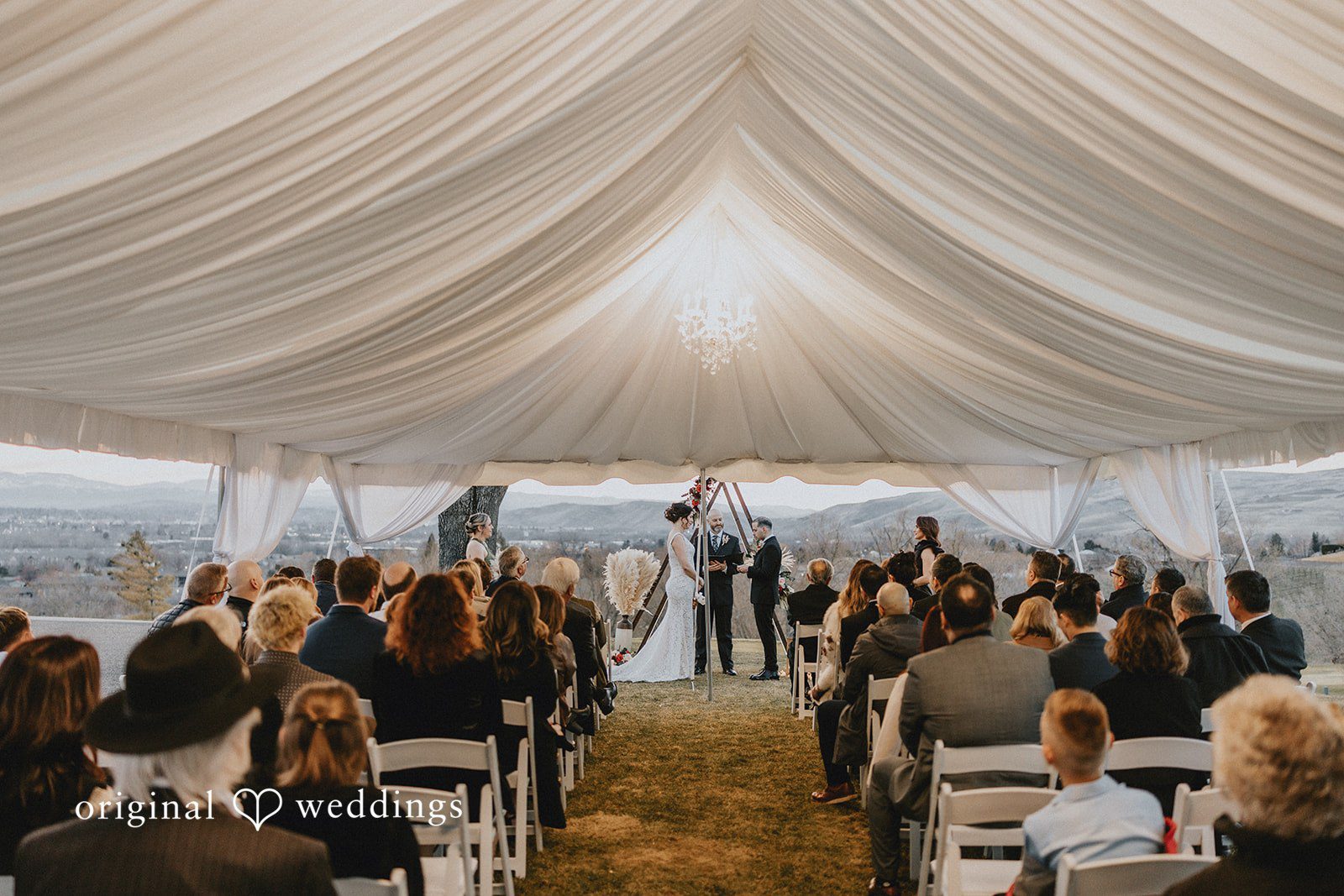 The ceremony under the tent feels lively and full of guests, beautifully captured through Seattle wedding photography.