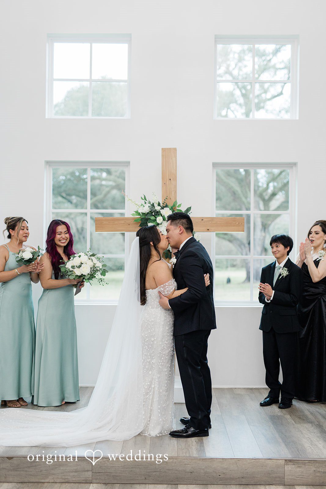 Dominic + Erika Joy Couple Sharing a kiss in the center of an aisle.