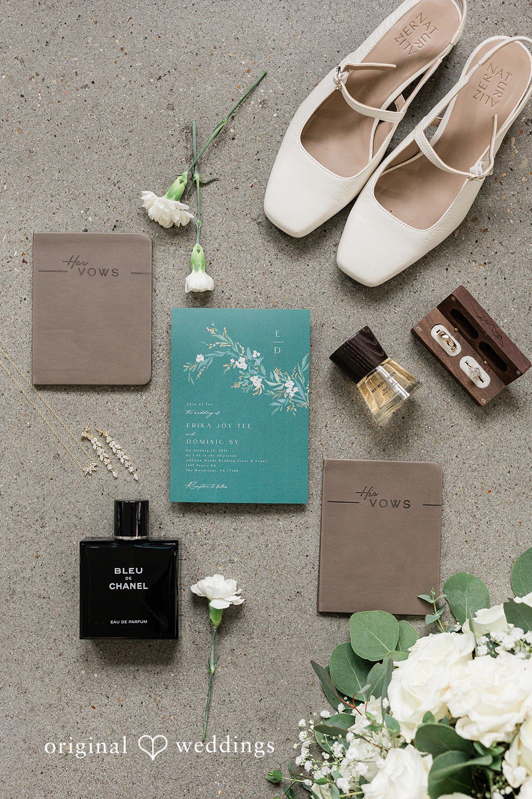 Dominic + Erika Joy A flat-lay display with light beige pointed-toe flats, teal and brown paper invitations, and a dark perfume bottle.