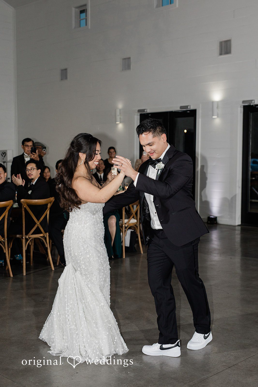 Dominic + Erika Joy Couple in wedding attire smiling and dancing together,