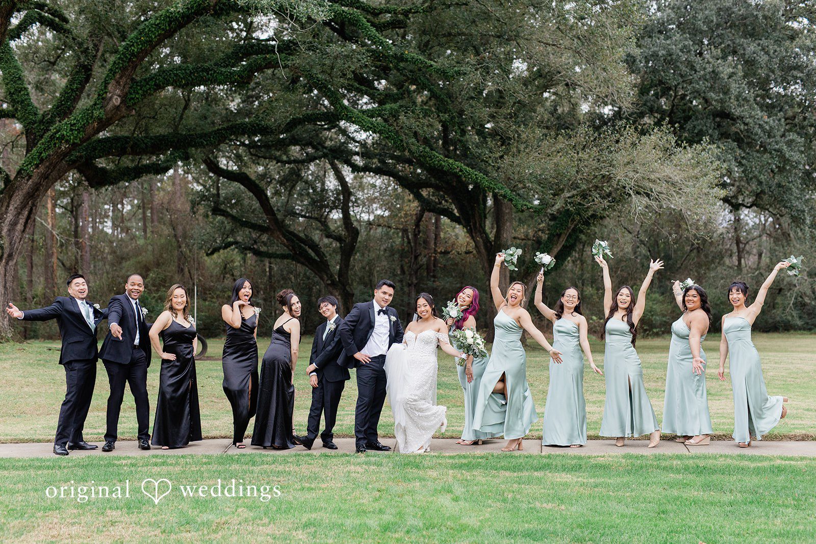 Dominic + Erika Joy Wedding party cheering on a lawn with raised arms and bouquets captured by Houston wedding photographers from original weddings at Addison Woods.