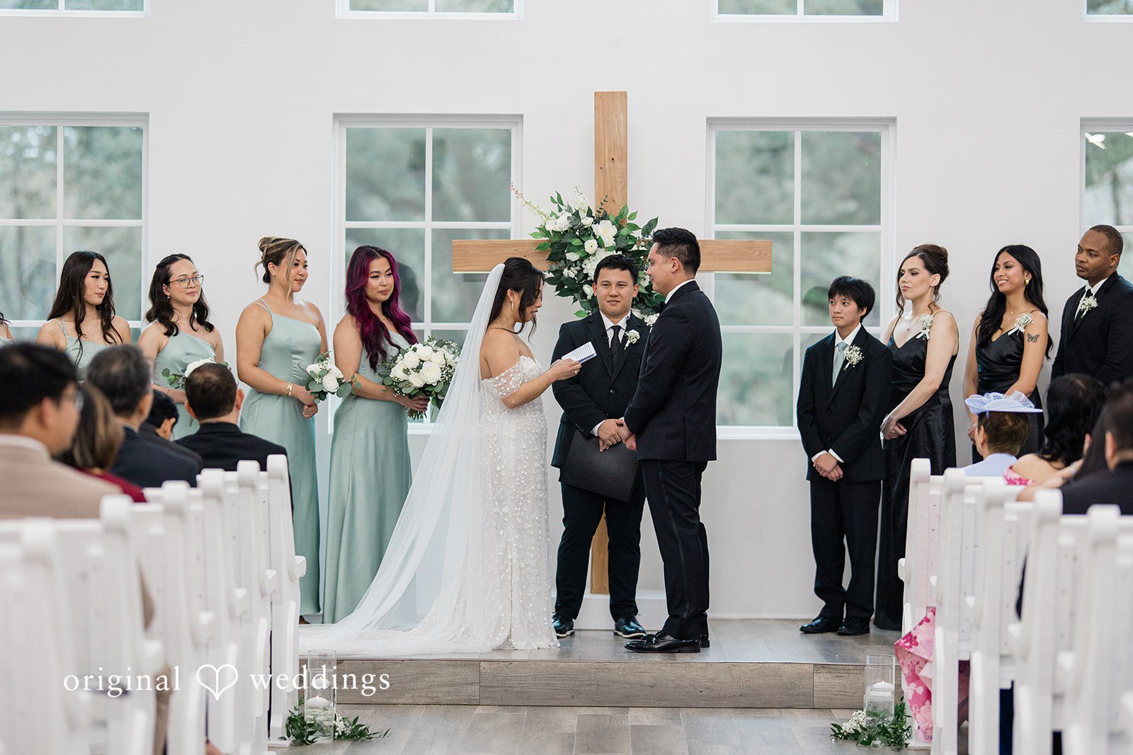 Dominic + Erika Joy Bride reading vows to groom at a wooden cross altar at Addison Woods.