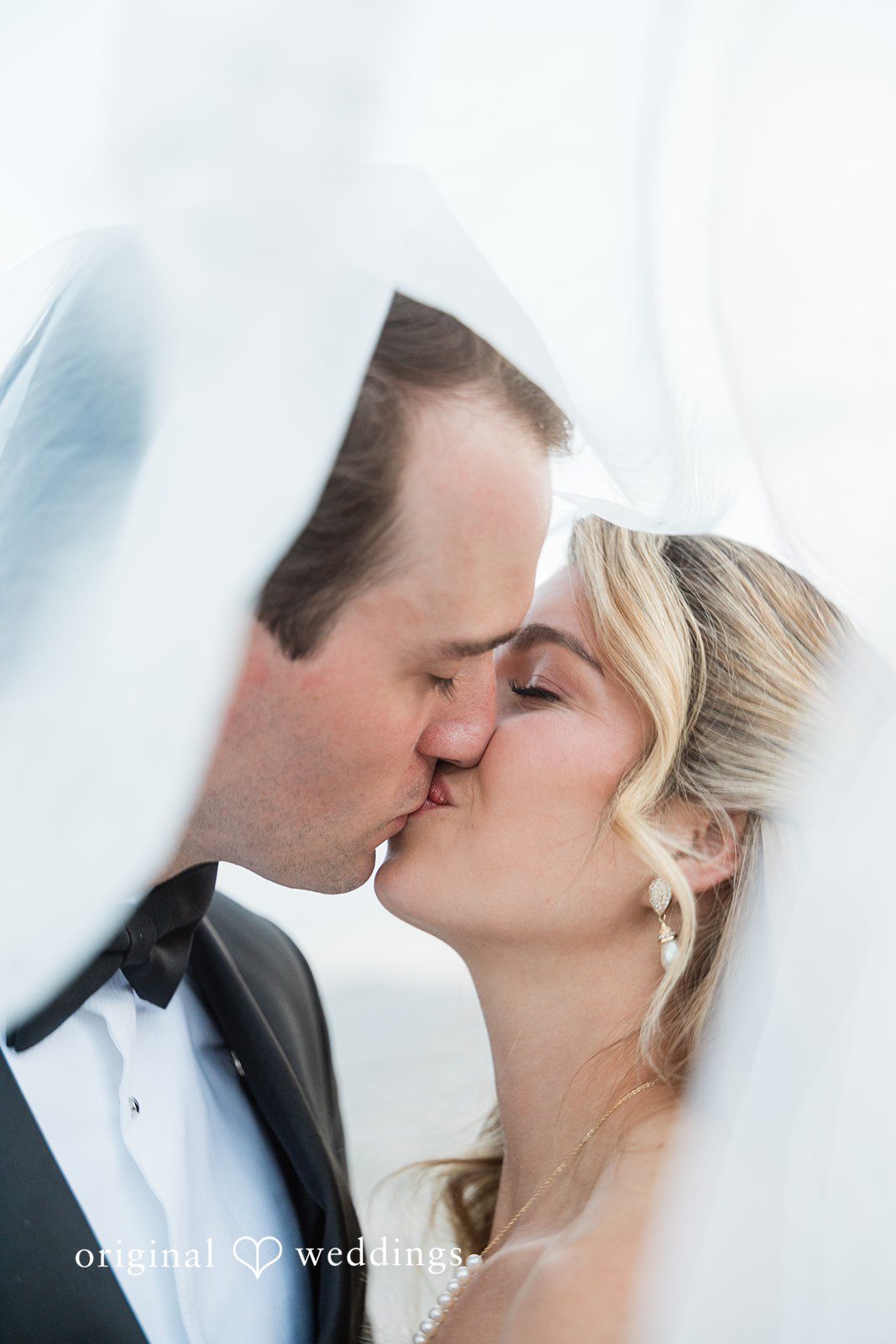 Kathryn + Calum Couple kissing beneath the floral arch during sunset portraits