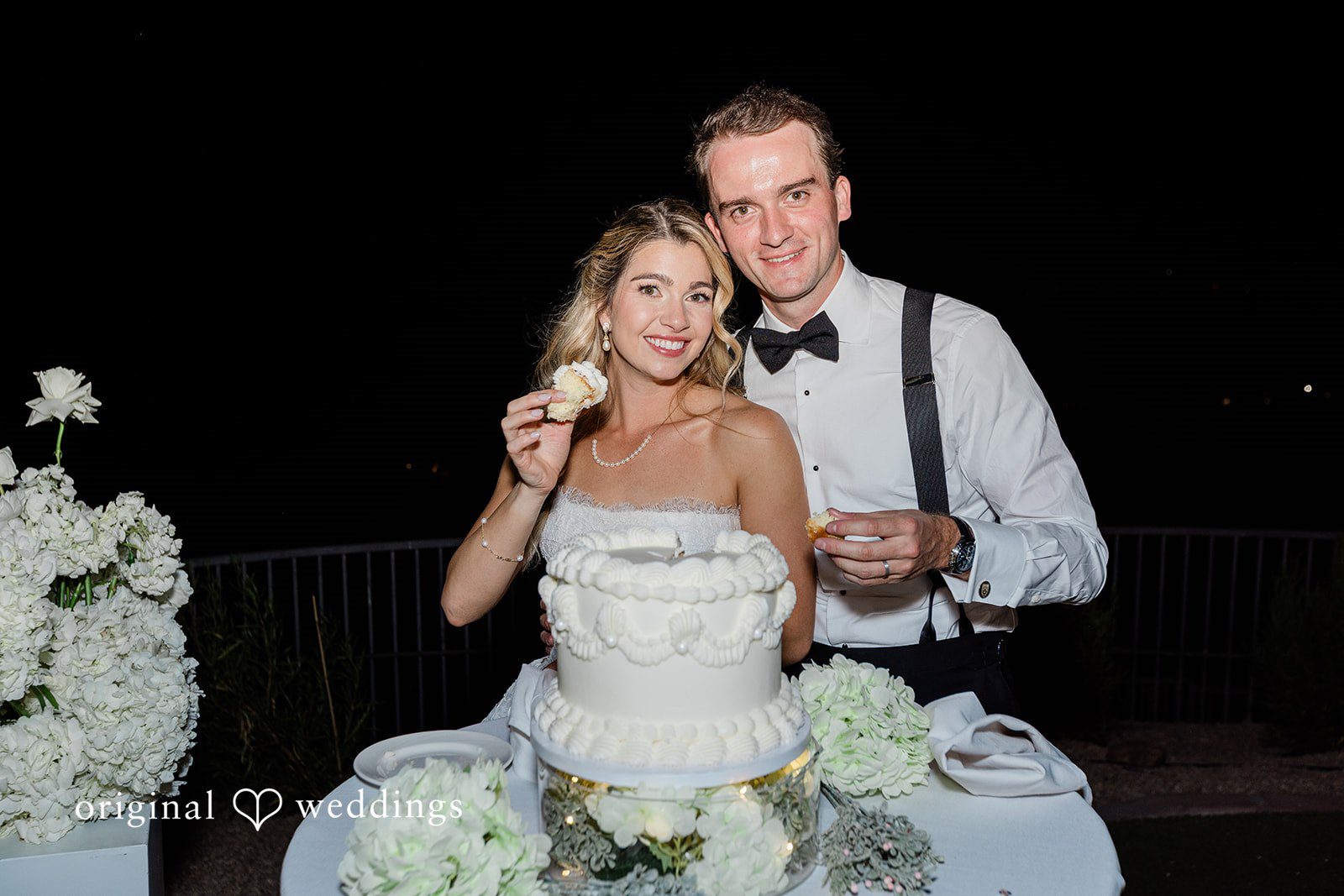 Kathryn + Calum Bride and groom posing together in front of the wedding cake