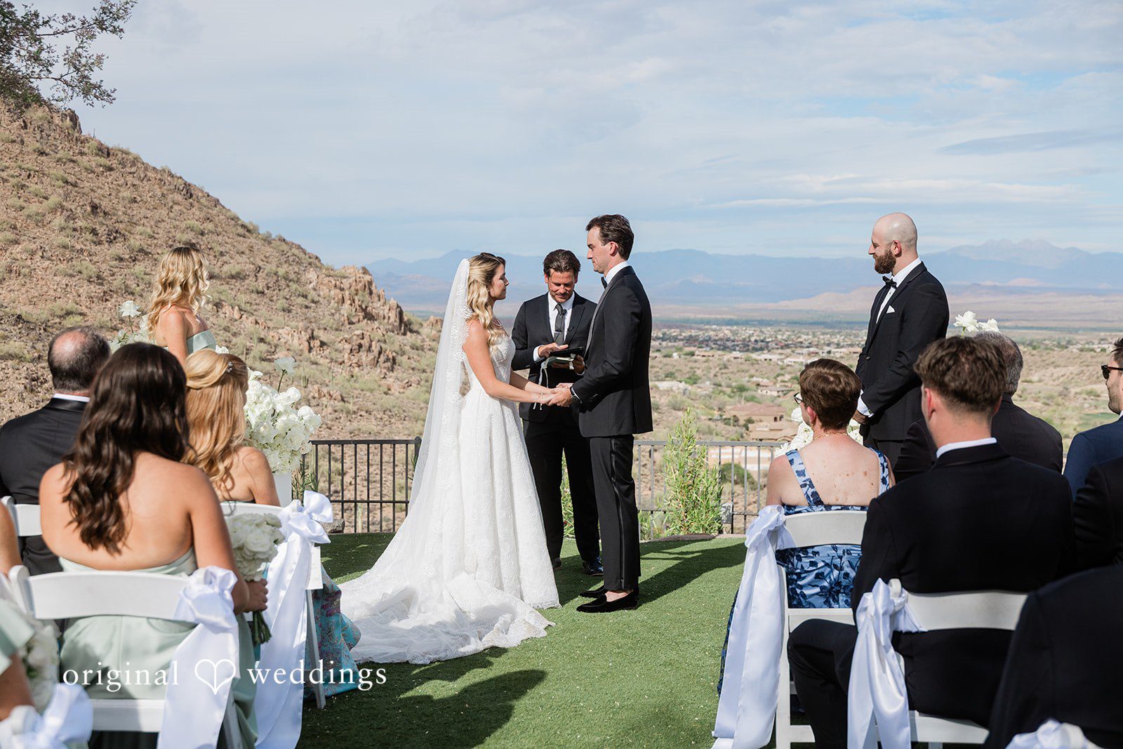 Kathryn + Calum Couple holding hands during their wedding vows at the ceremony site