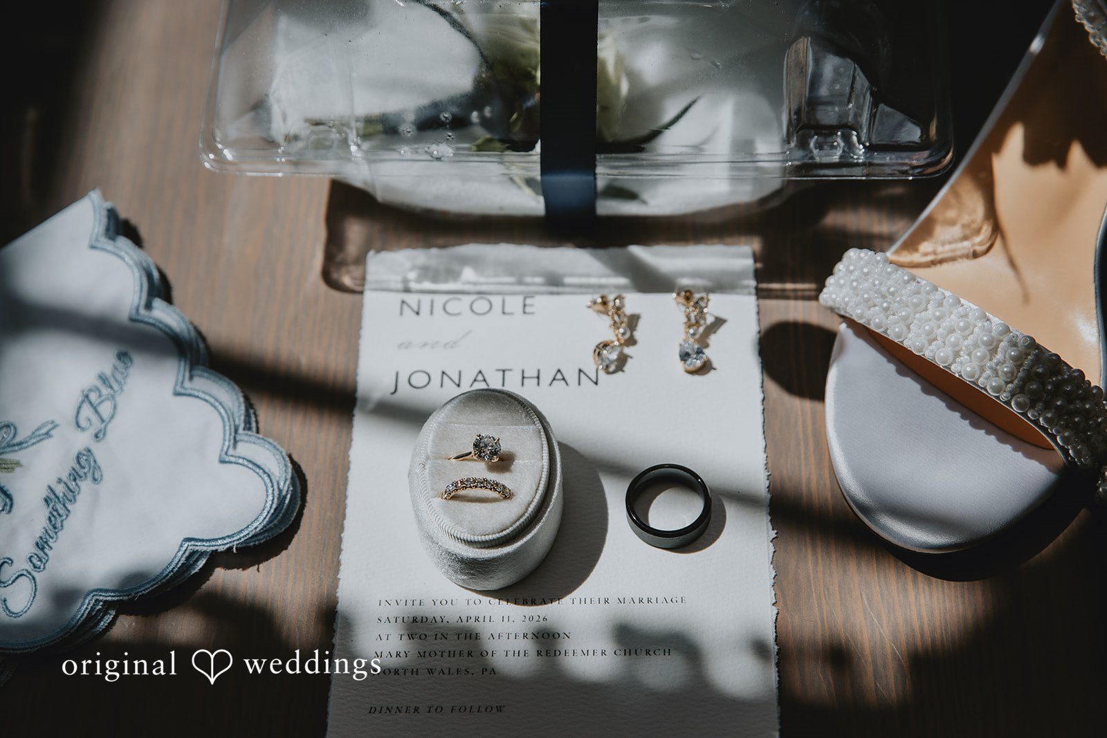 Wedding detail flat lay with rings, shoes, and invitation suite