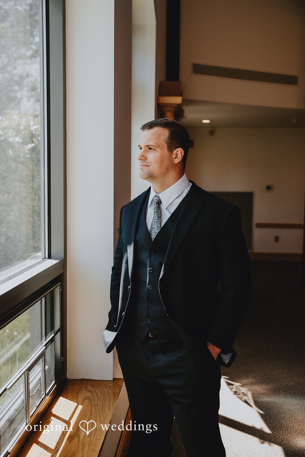 Groom portrait by the chapel window before the ceremony