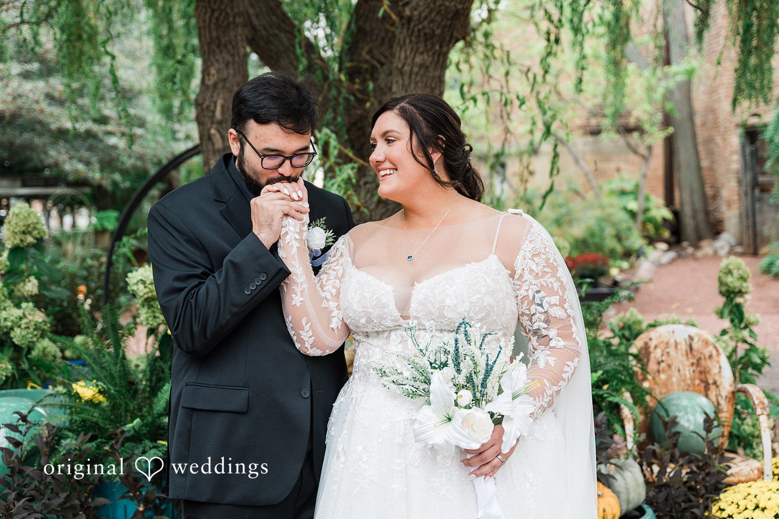 Romantic groom kissing bride’s hand at Blumen Gardens