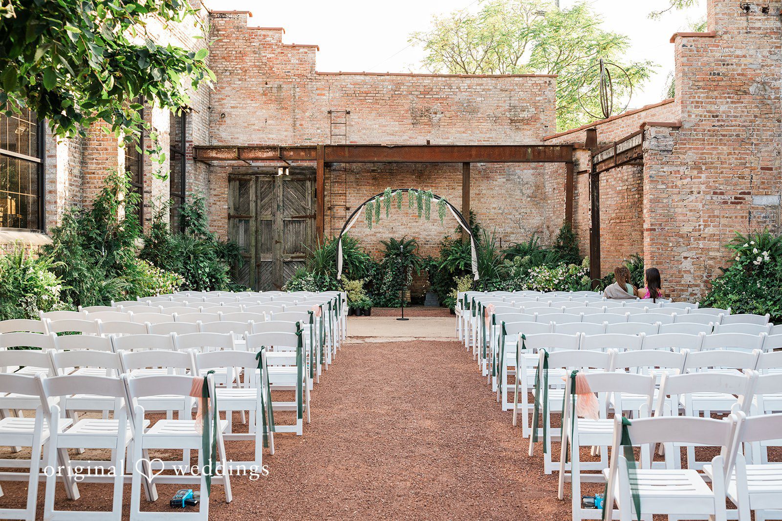 Stylish wedding sitting decor with white chairs at Blumen Gardens