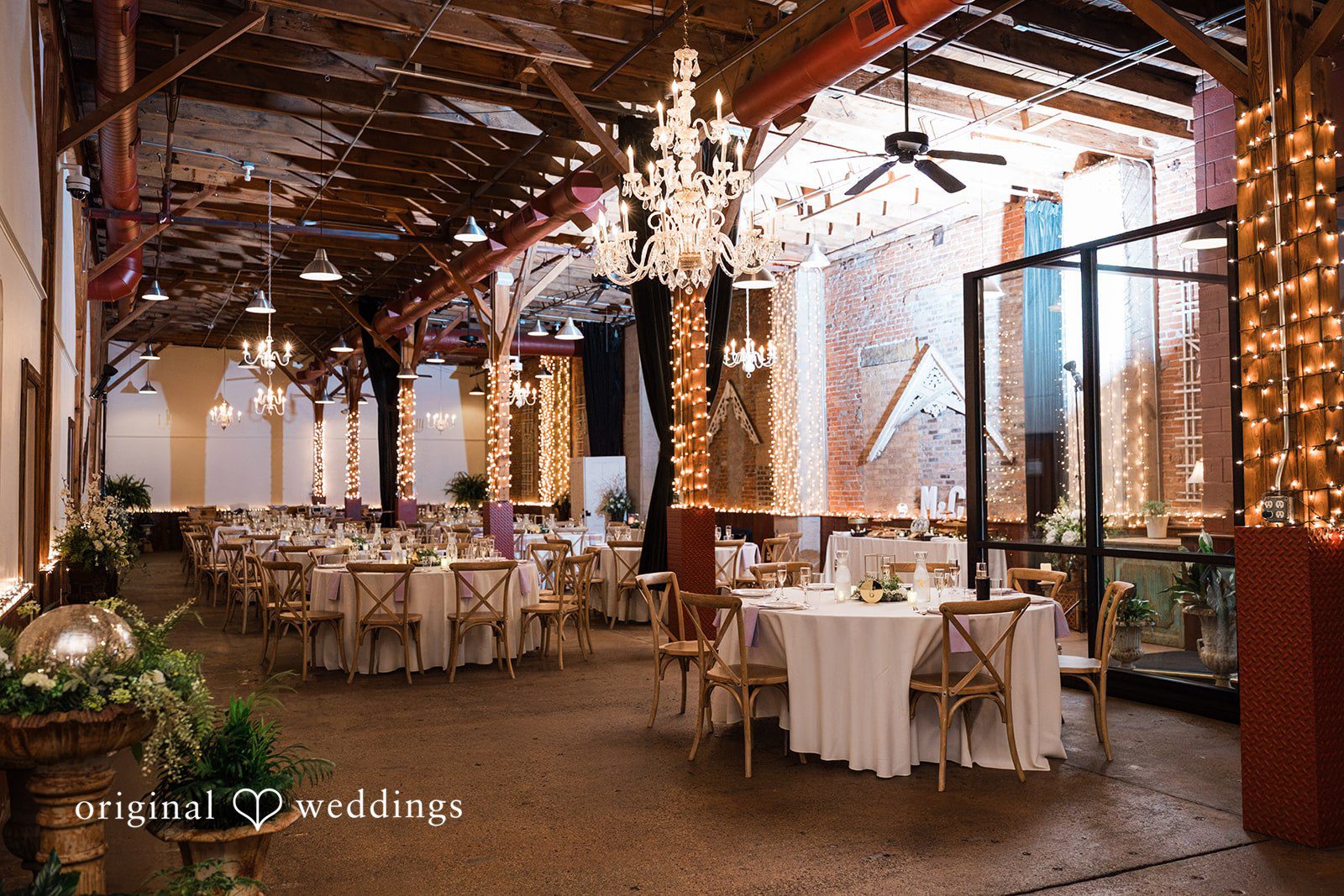 Elegant wedding reception setup with lighting and dining tables at Blumen Gardens