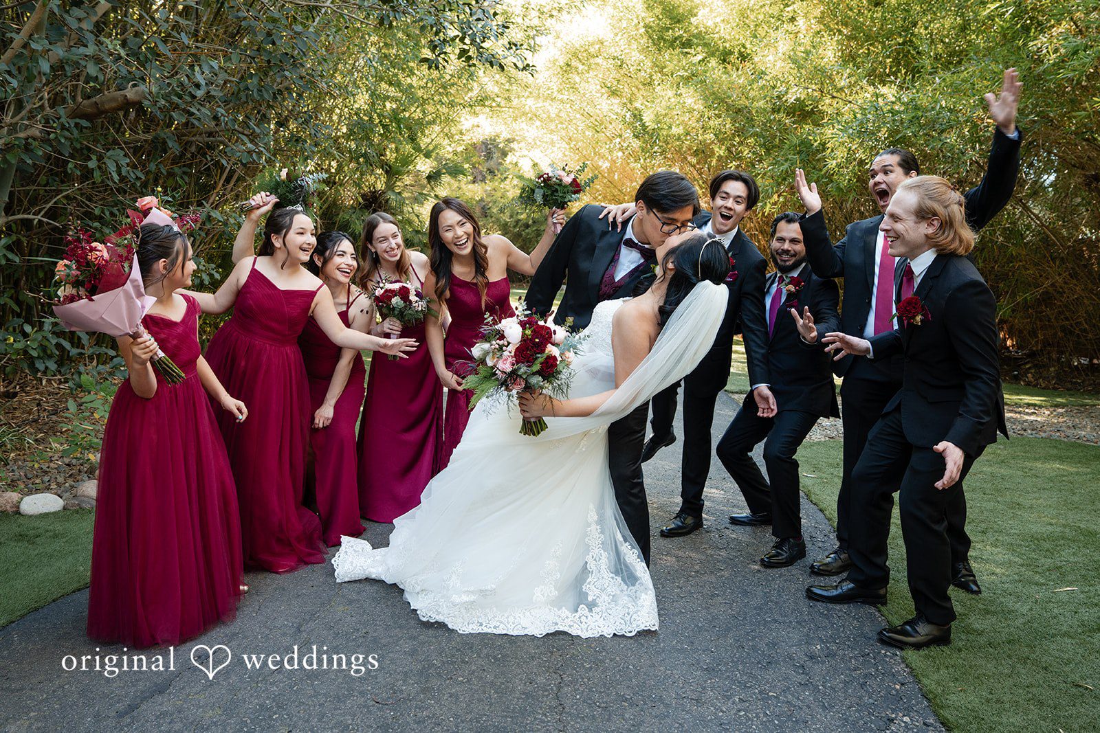 The couple shares a romantic kiss with cheers from their bridal party
