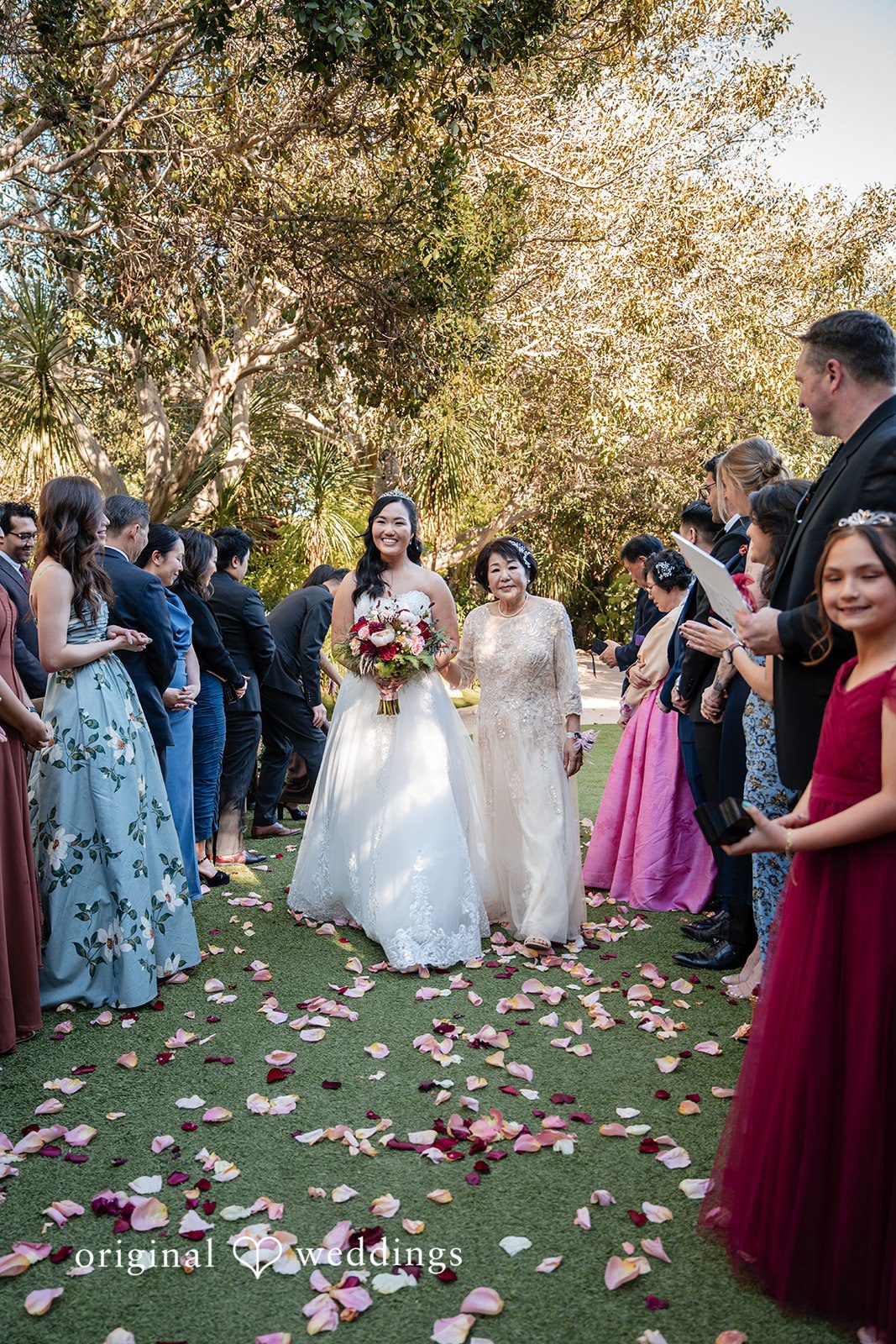 The bride's mother escorts the bride down the aisle