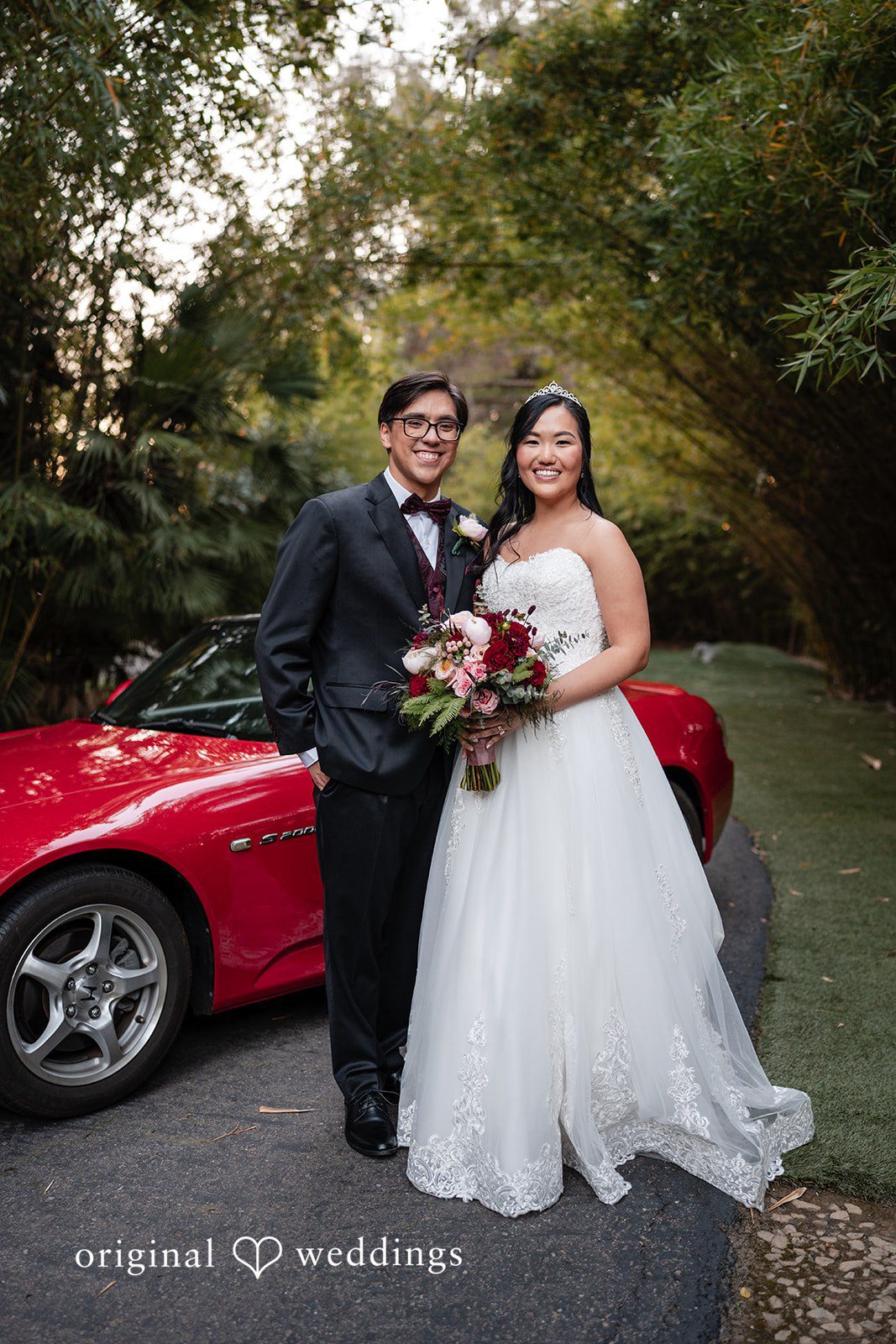 A stunning portrait of the couple by the sleek red car