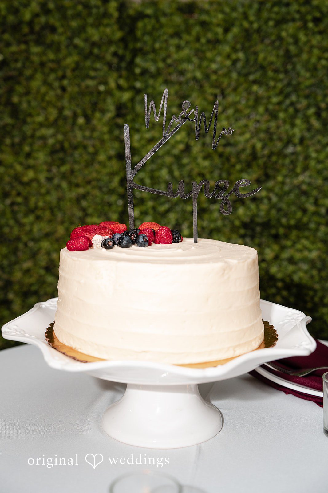 An all-white cake topped with strawberries and grapes