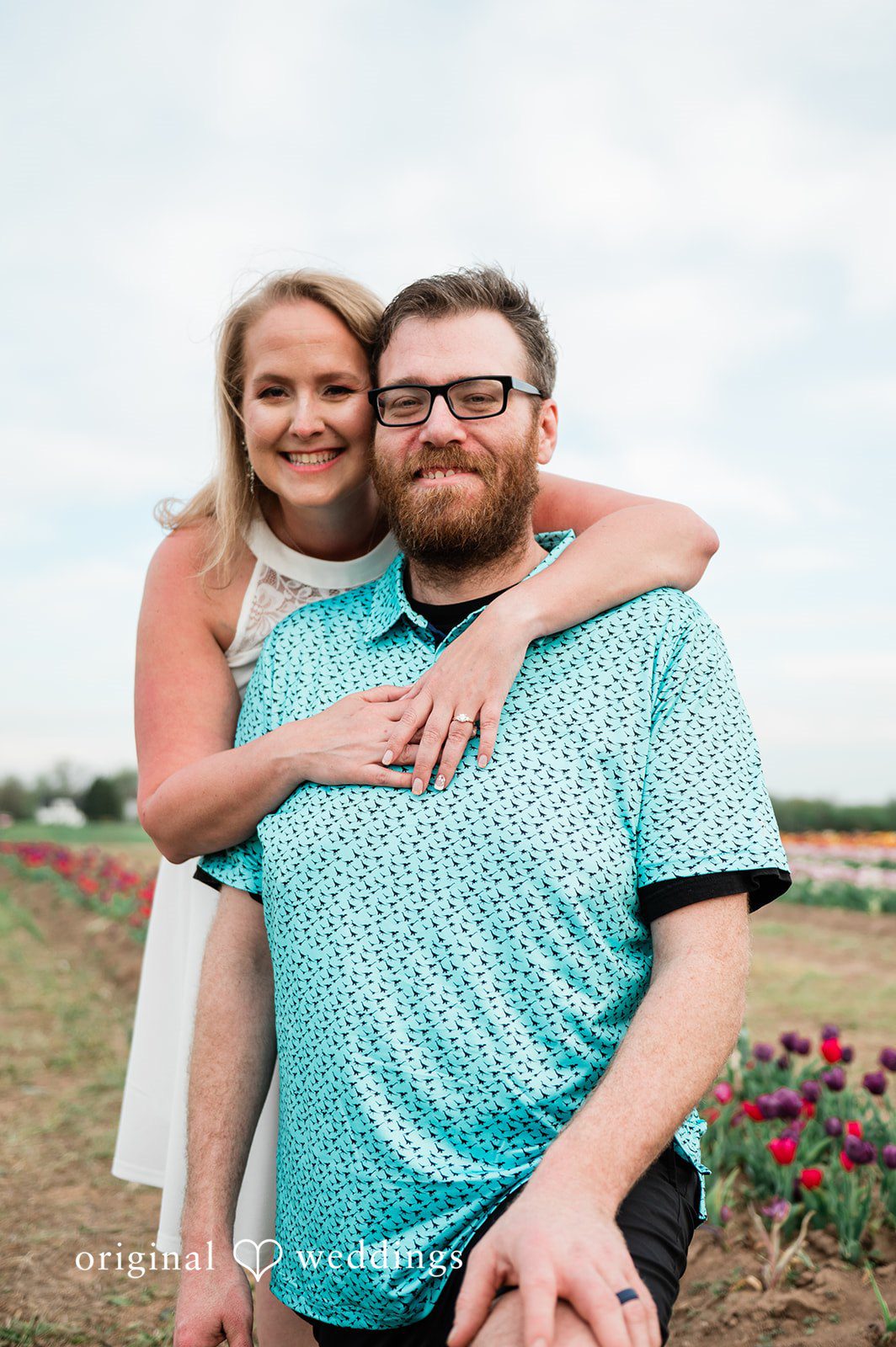 Suzanna + Morgan Engagement portrait of the couple smiling among blooming flowers