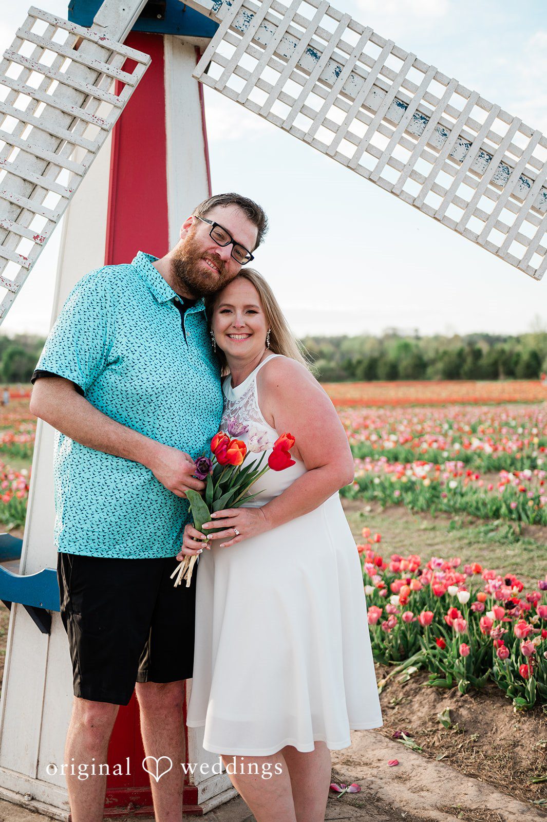 Suzanna + Morgan Playful engagement portrait in front of a windmill at Burnside Farms