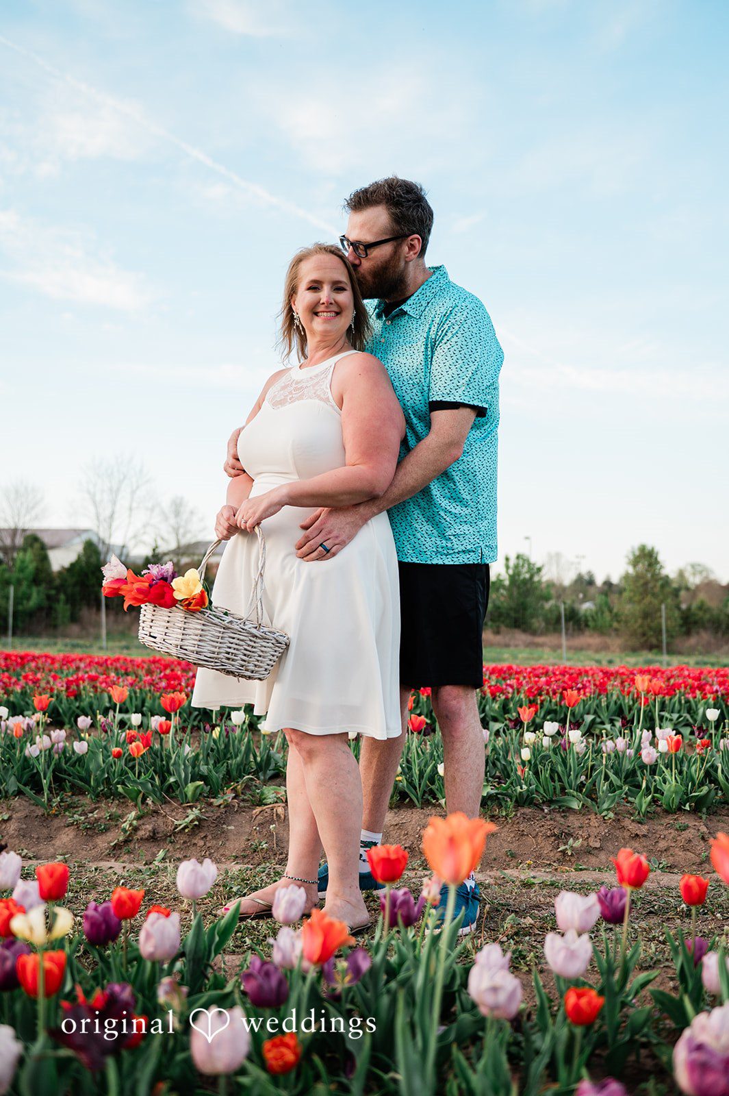 Suzanna + Morgan Romantic engagement couple posing among colorful tulip fields at Burnside Farms