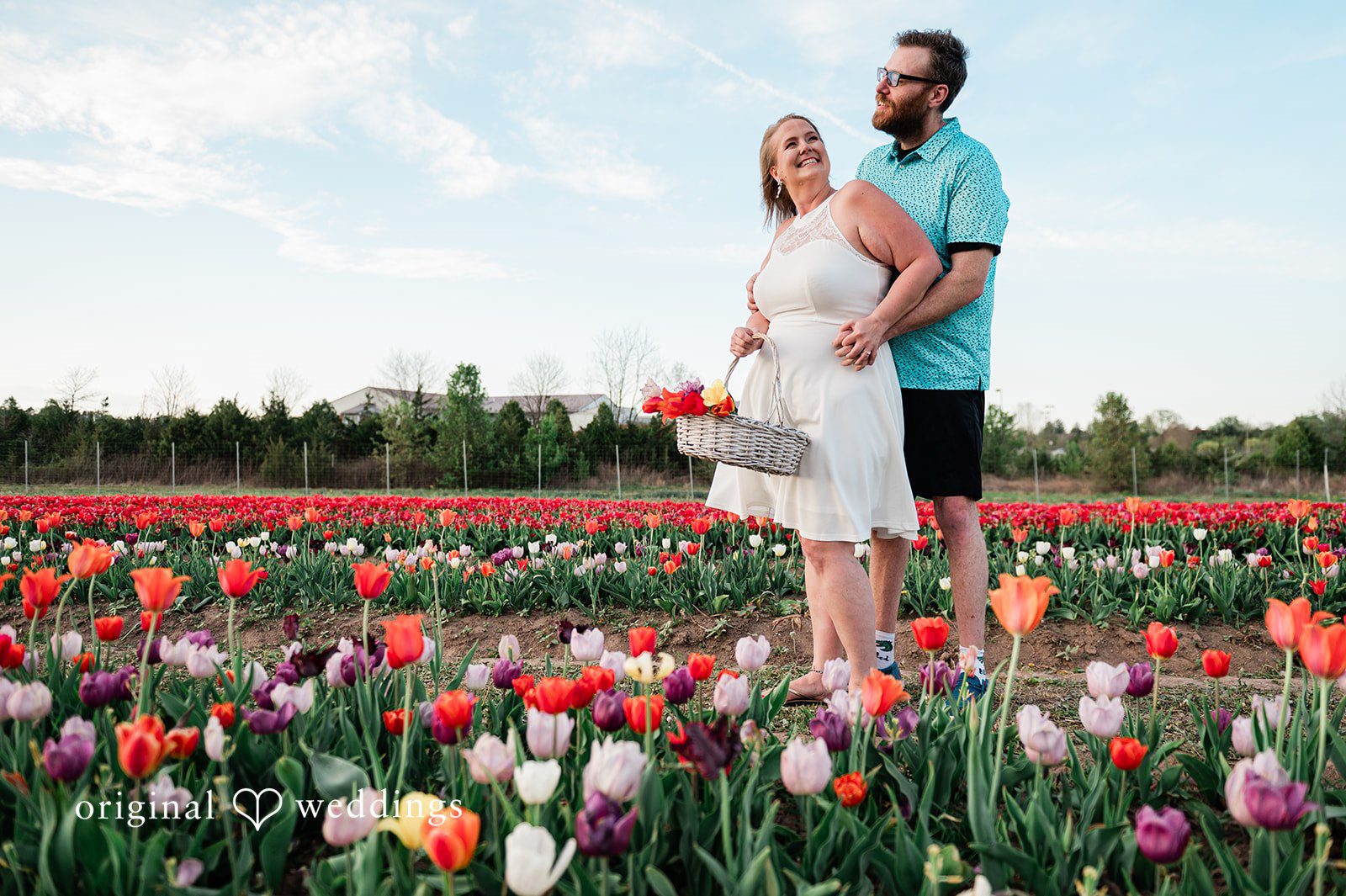 Suzanna + Morgan Playful engagement portrait in front of a windmill at Burnside Farms