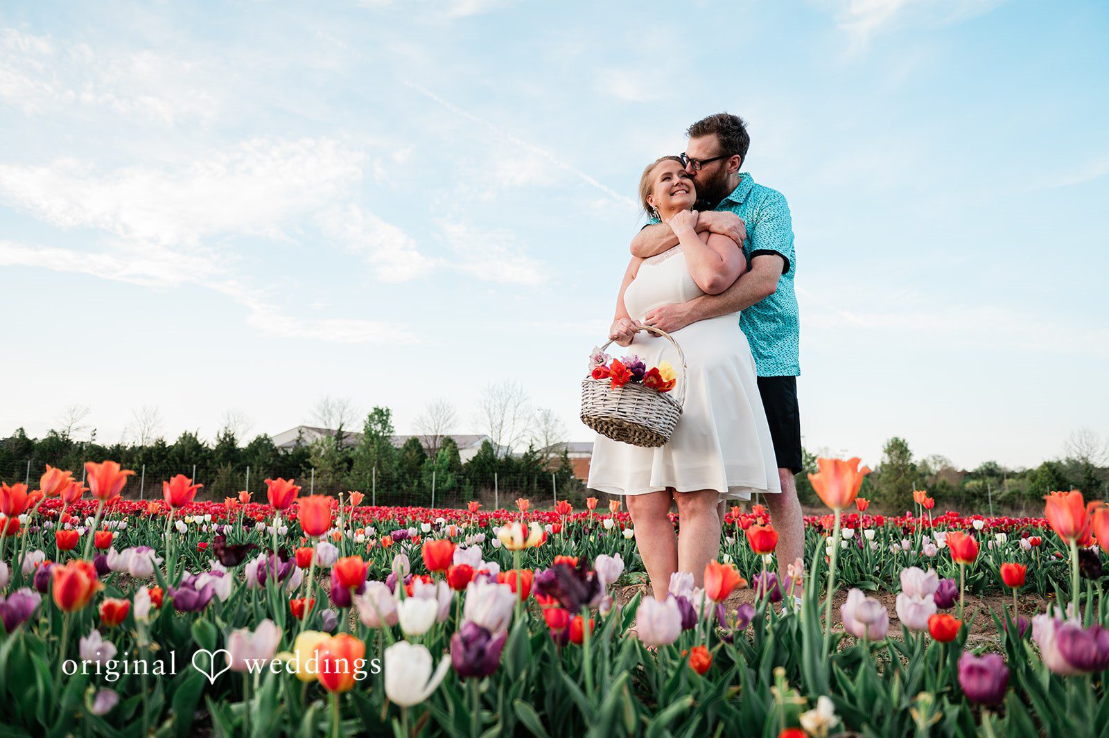 Suzanna + Morgan Couple joyfully picking flowers together during their engagement session