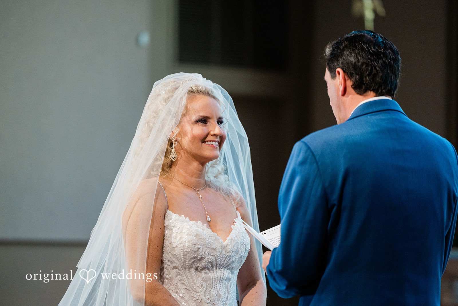 Medium close-up of the bride and groom looking at each other during the vows.