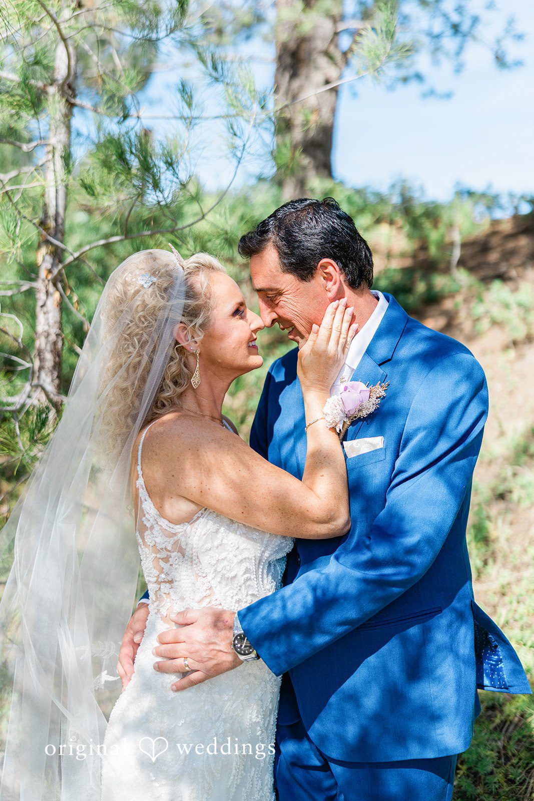 Bride and groom embracing and smiling closely during a portrait session.