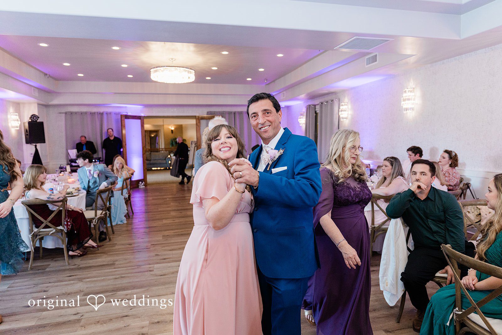 Groom dancing with a woman in a pink dress during the reception.