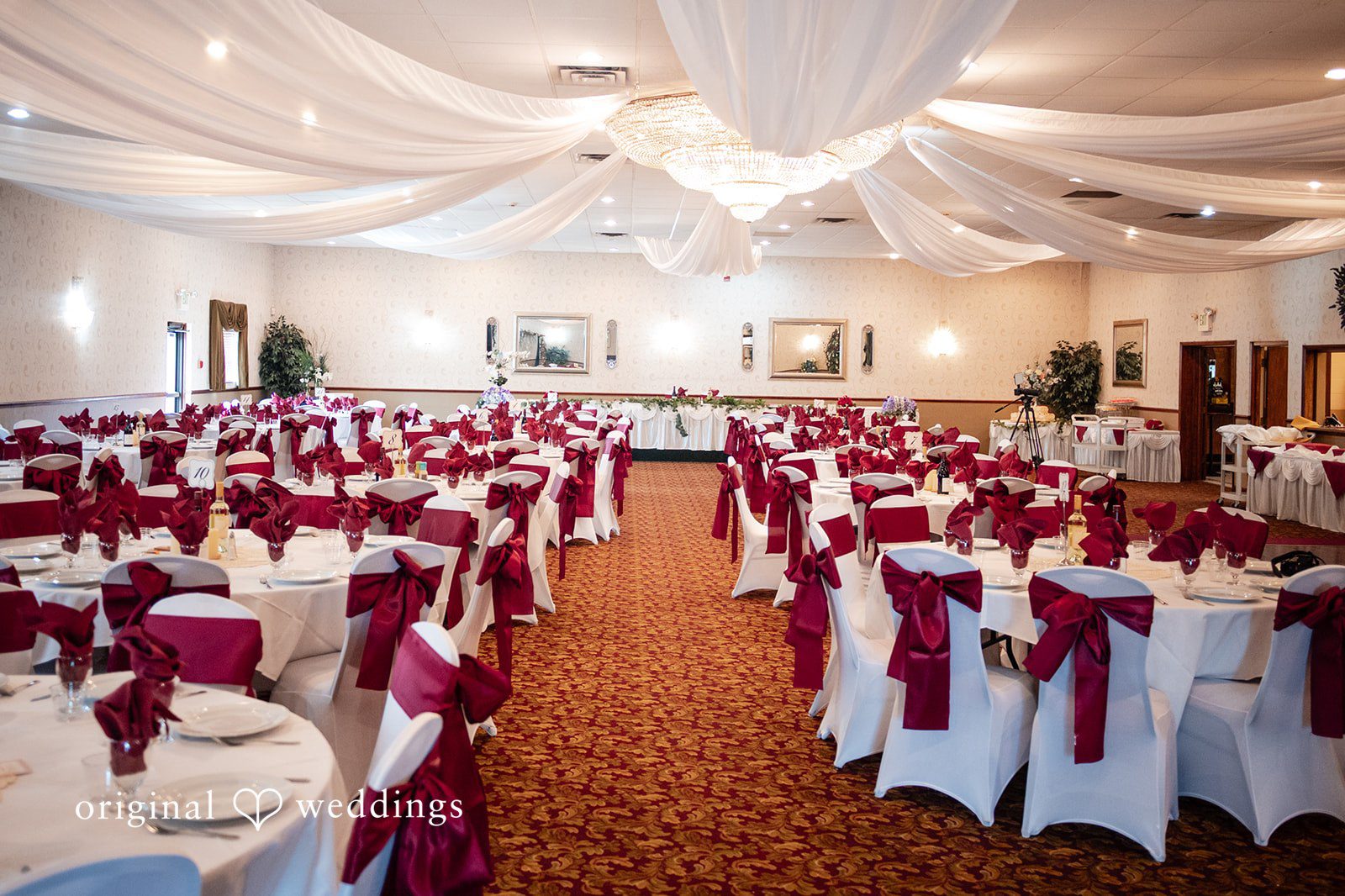 Elizabeth + Aldo Indoor reception setup at Chetnik Memorial Hall with elegant burgundy decor