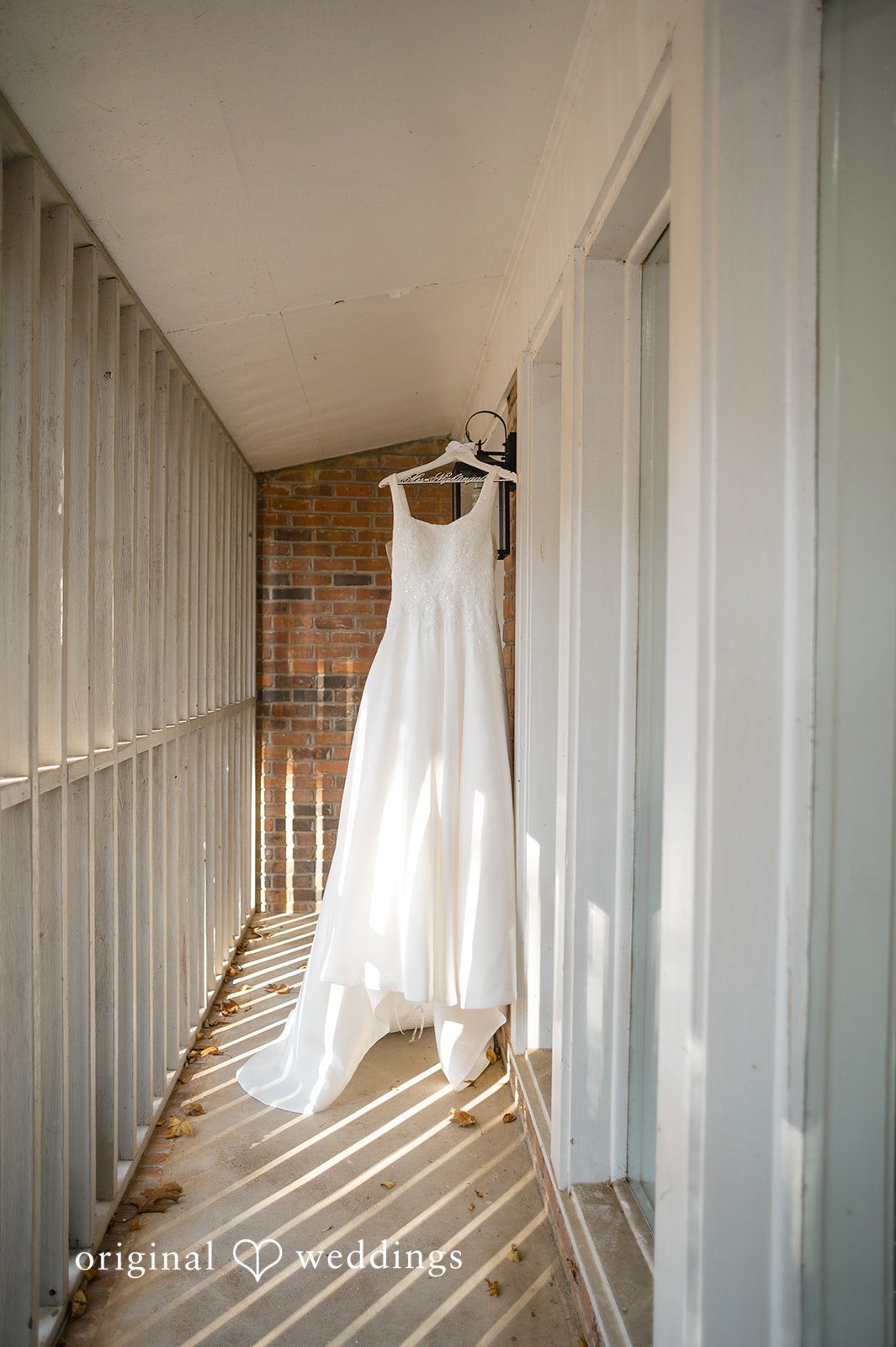 Elegant wedding dress hanging in soft natural light at Christ Covenant Sandy Springs