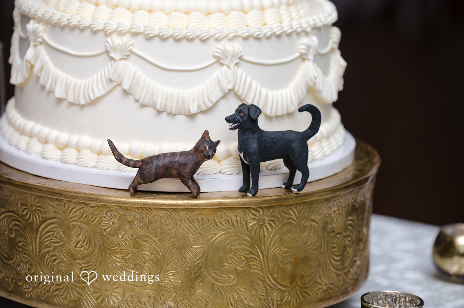 Cute wedding cake detail featuring cat and dog figurines during reception celebration.