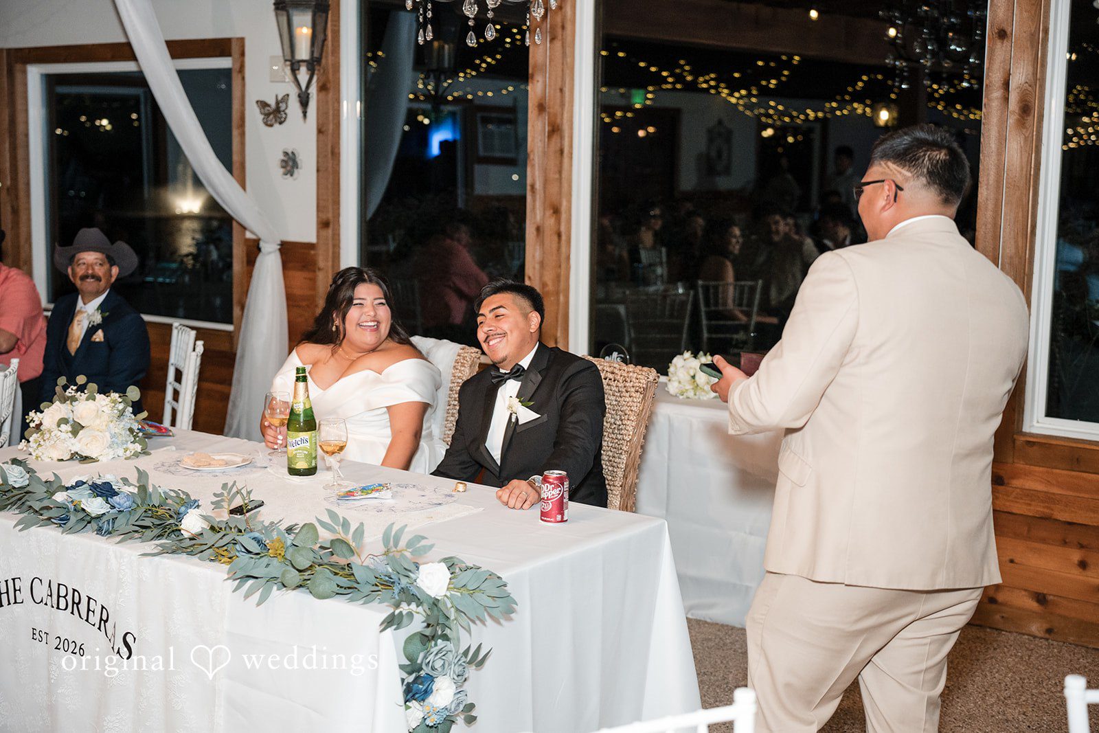 Cecilia + Jose Houston Wedding Photographers capturing bride and groom seated at reception table at Circle of Seven Ranch by Original Weddings