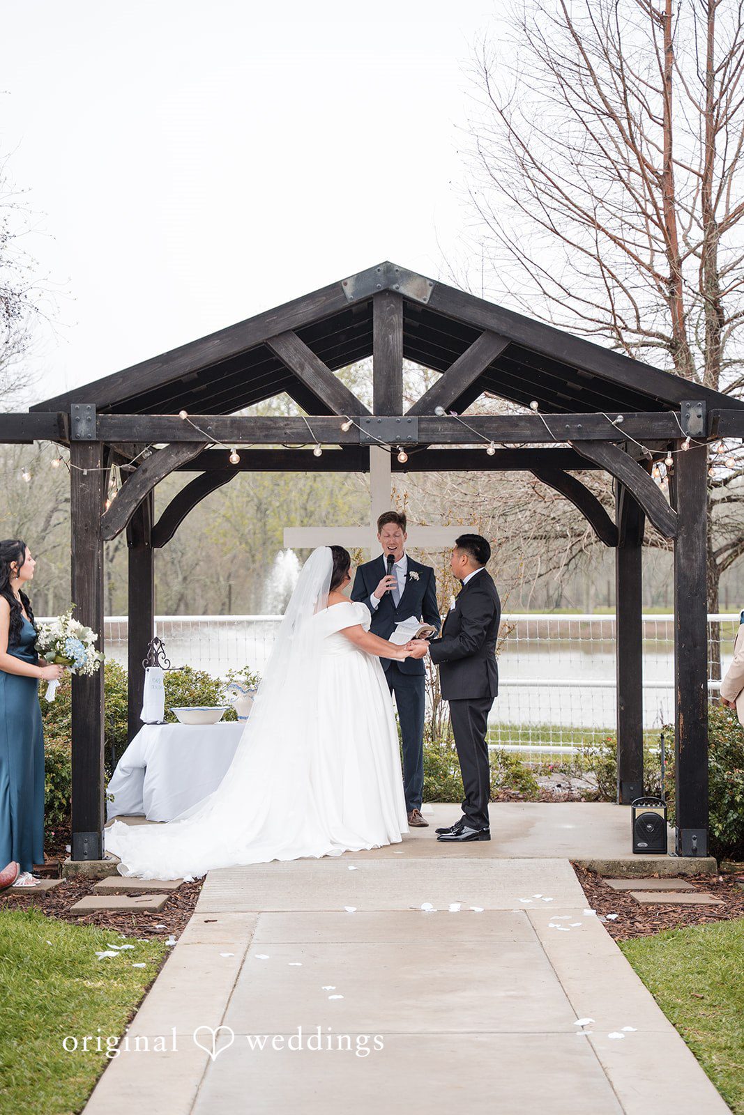 Cecilia + Jose Elegant wedding ceremony moment as bride and groom hold hands and listen to priest