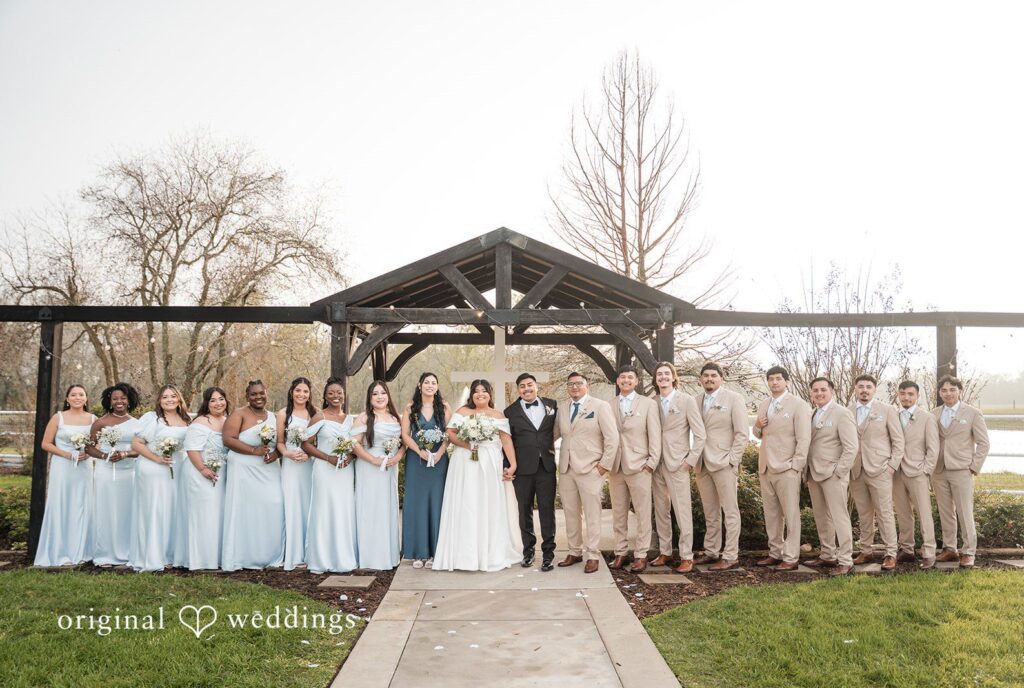 Cecilia + Jose Houston Wedding Photographers capturing group photo of couple with bridesmaids and groomsmen at Circle of Seven Ranch by Original Weddings
