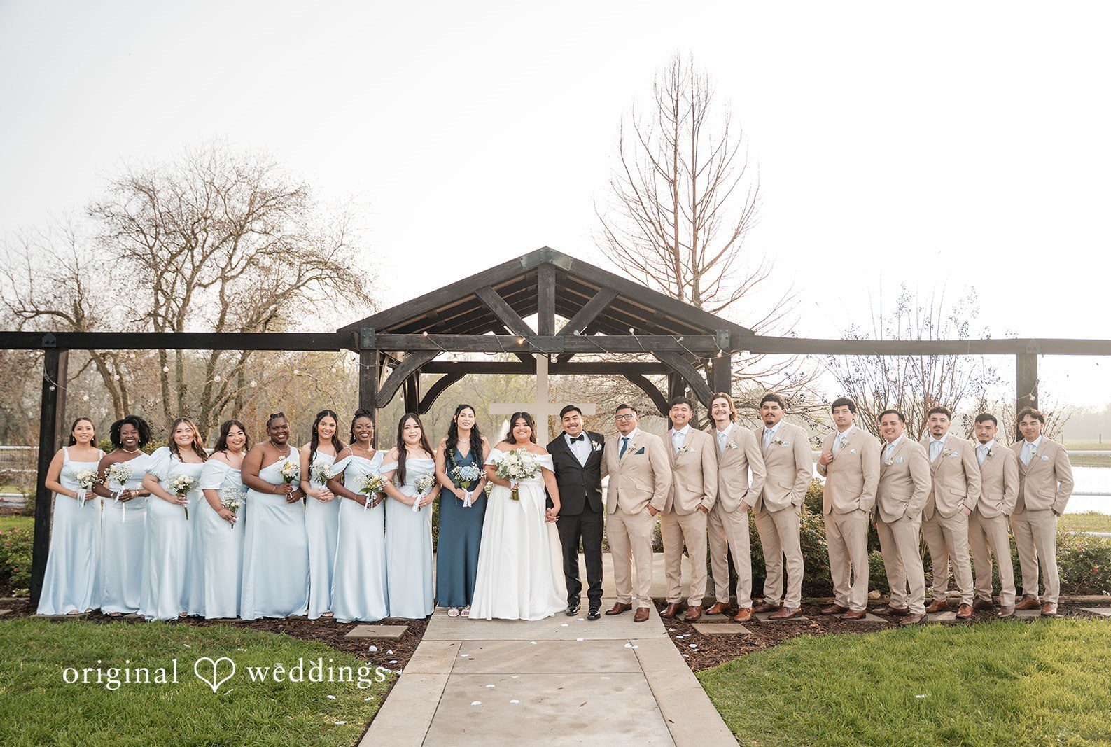 Houston wedding photographers capturing group photo of couple with bridesmaids and groomsmen at Circle of Seven Ranch by Original Weddings